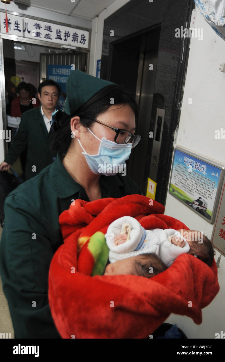 Un travailleur médical chinois porte les deux sœurs siamois avant qu'ils ont été transférés à l'Hôpital pour enfants de l'Université Fudan à Shanghai fo Banque D'Images