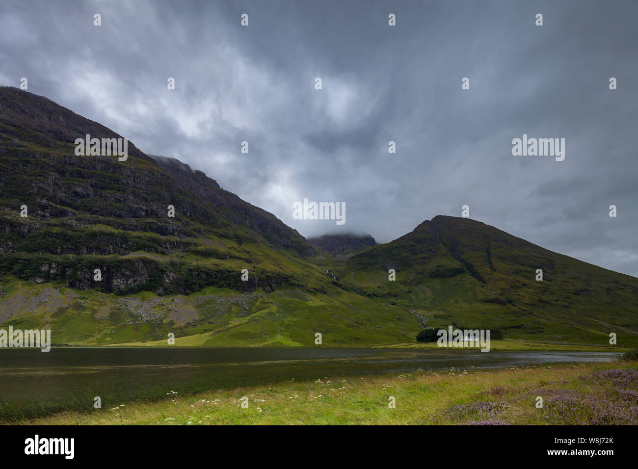 Un paysage pittoresque d'une maison entourée d'un loch loch (Achtriochtan) et les montagnes à Glencoe, les Highlands écossais Banque D'Images