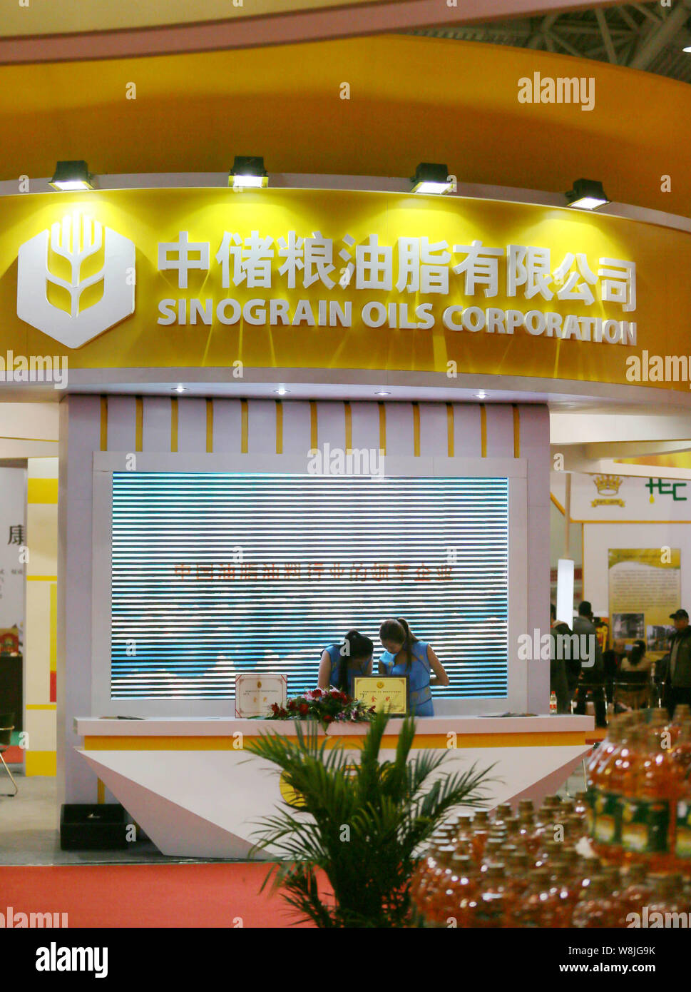 --FILE--employés chinois sont vus sur le stand de Sinograin Oils Corporation, une filiale de Sinograin, également connu sous le nom de réserve de céréales de la Chine Corporatio Banque D'Images
