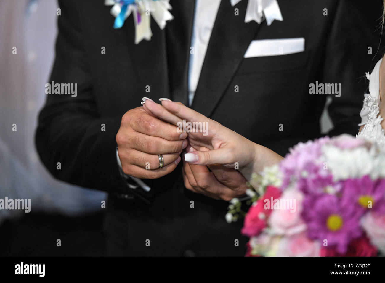 Close up de la part de la mariée met un anneau de mariage sur le doigt de mariés. Les mains de l'époux et l'épouse, c'est portant un anneau sur le doigt sur le jour de Banque D'Images
