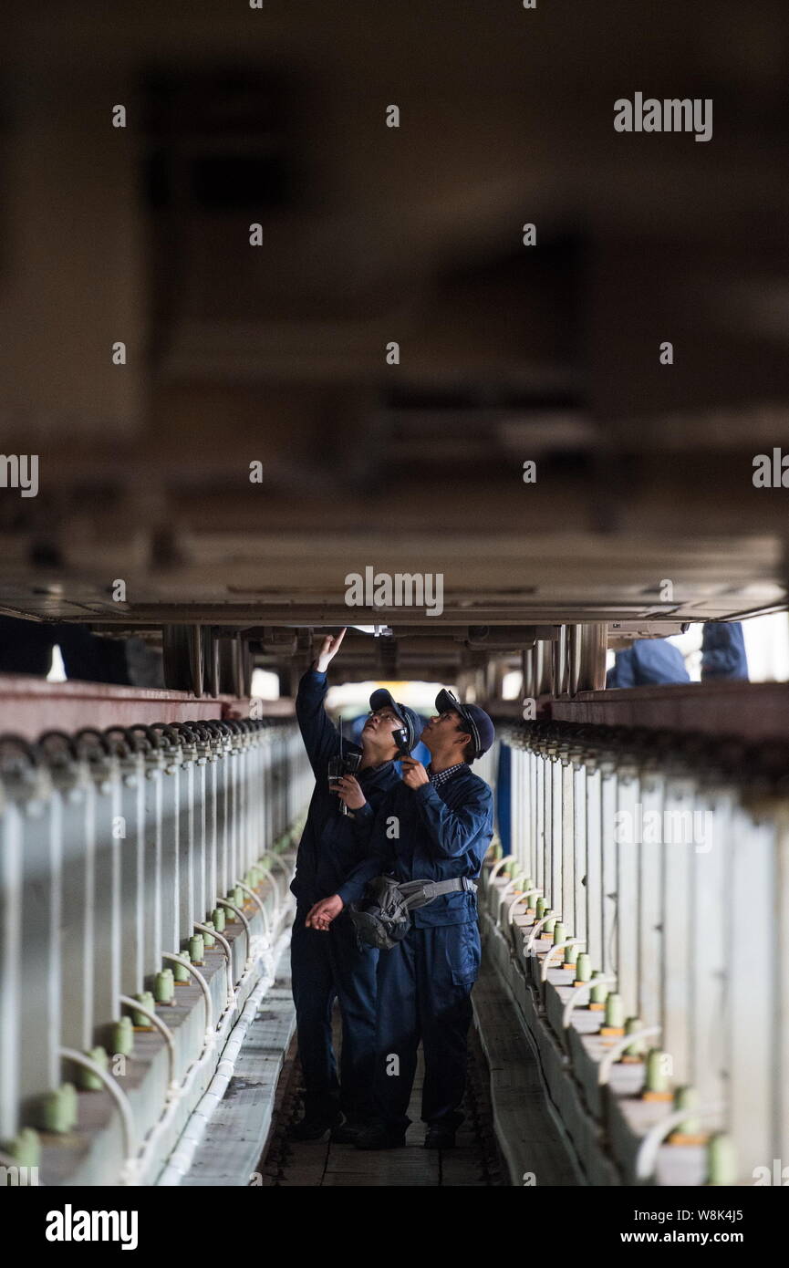 Techniciens chinois examiner un CRH (China railway High-speed), le train pour le prochain Nouvel An chinois ou la fête du printemps à la maintena Banque D'Images