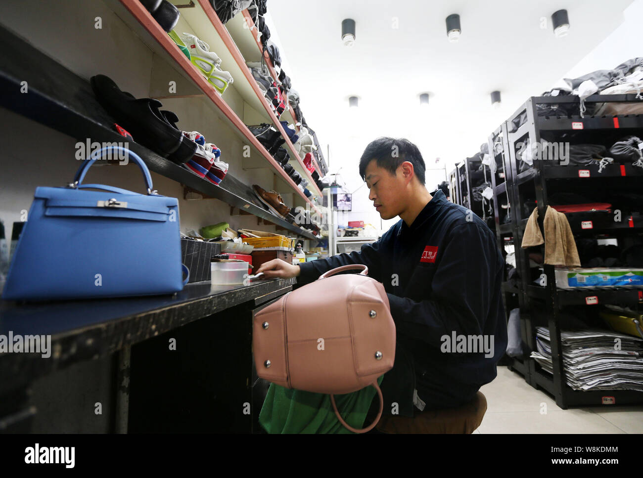 Un travailleur chinois nettoie un Louis Vuitton sac à main en cuir à la Luo Ji maroquinerie atelier de réparation et de soins dans la ville de Chengdu, Chine du sud du Sichuan bauvin Banque D'Images