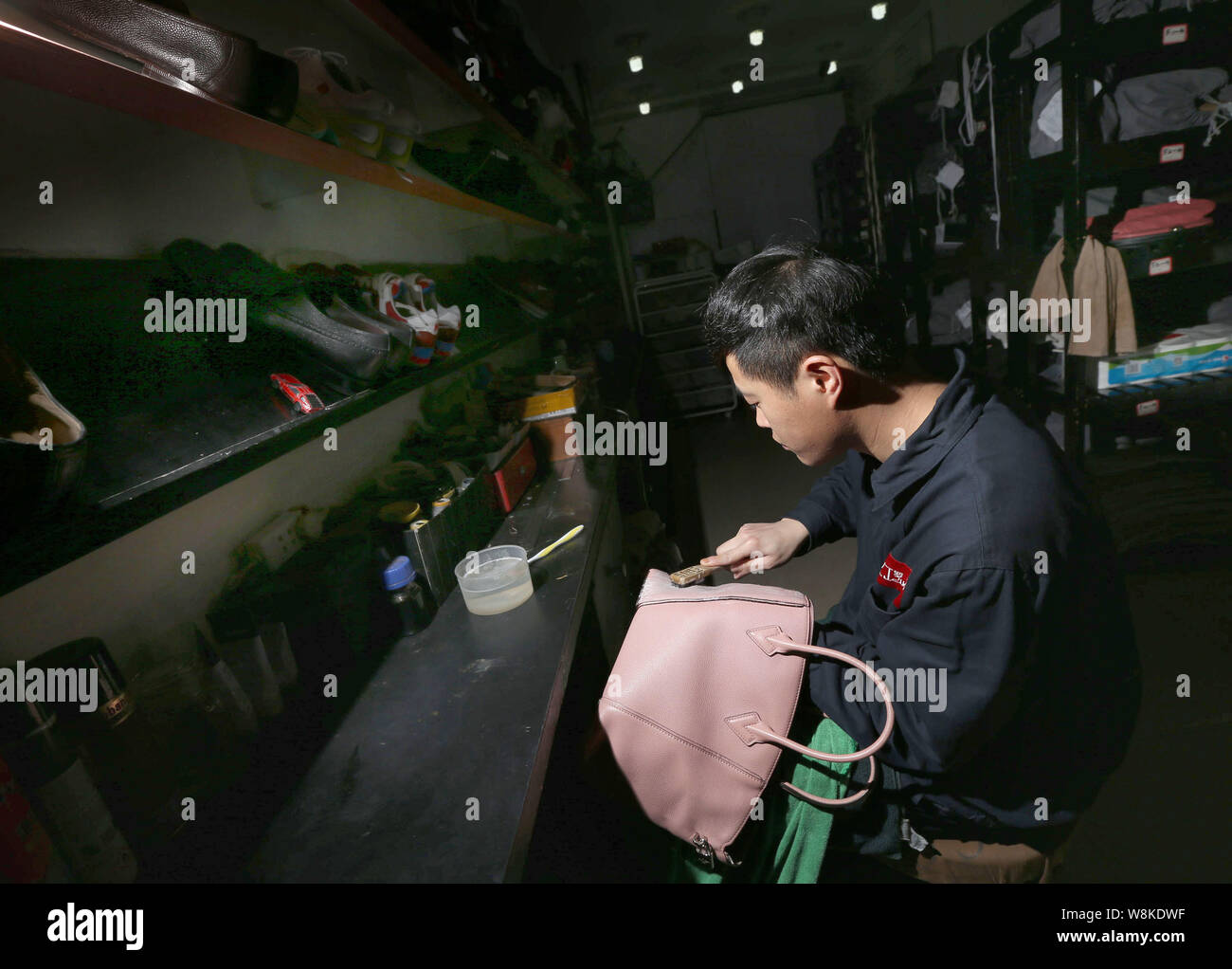 Un travailleur chinois nettoie un Vuitton sac main cuir à la Luo Ji maroquinerie atelier de réparation et de soins la ville de Chengdu, Chine du sud du