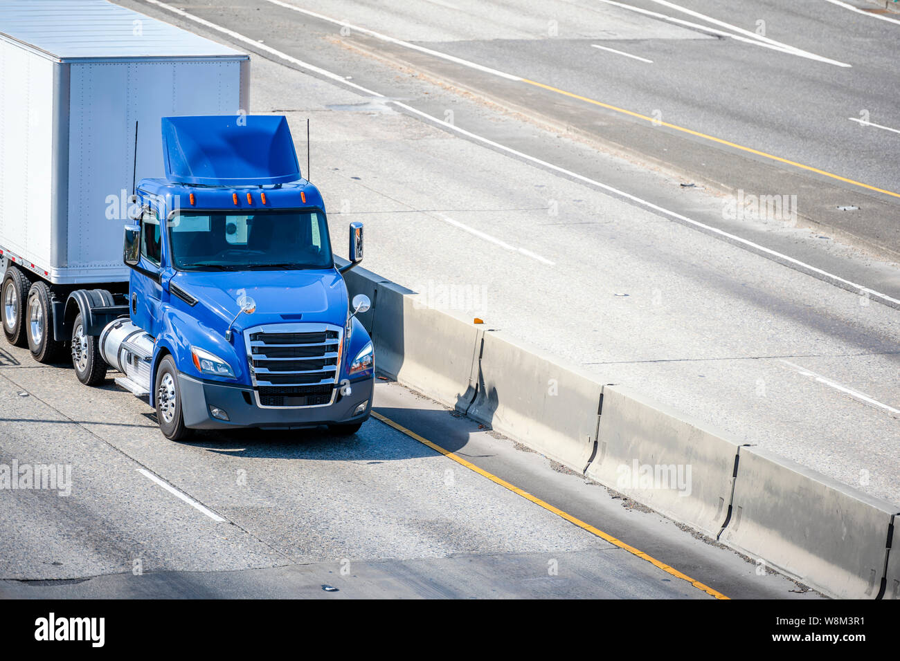 Camion semi-remorque bleu de qualité professionnelle avec porte ouverte semi-remorque vide se tenant sur le parking de l'entrepôt dans la zone industrielle en attente de la communication Photo Stock - Alamy