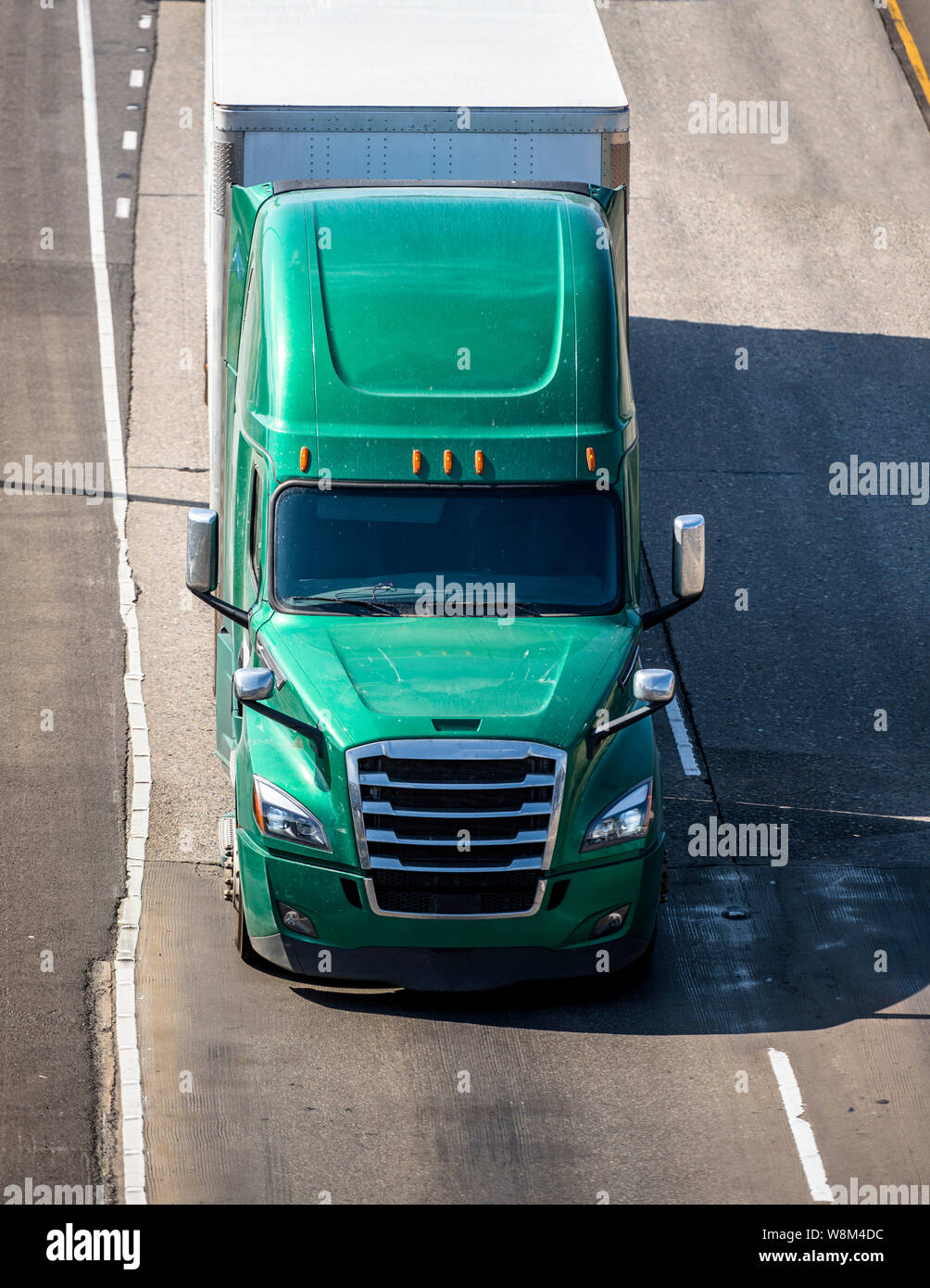 Gros camion long courrier professionnel vert bonnet semi lourd camion transportant du fret commercial dans la région de dry van semi-remorque pour le transport sur la livraison Banque D'Images