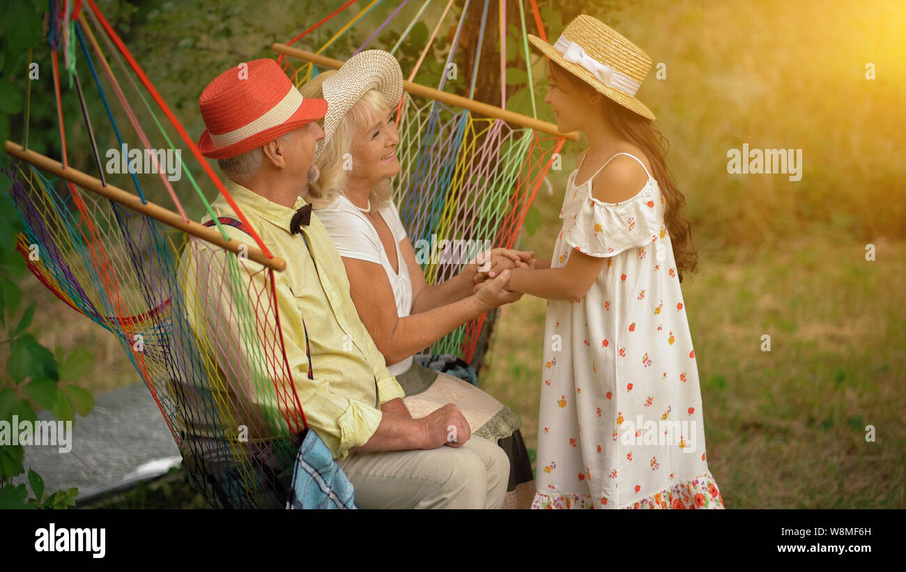 Le vieux couple est assis dans le hamac dans le jardin Banque D'Images