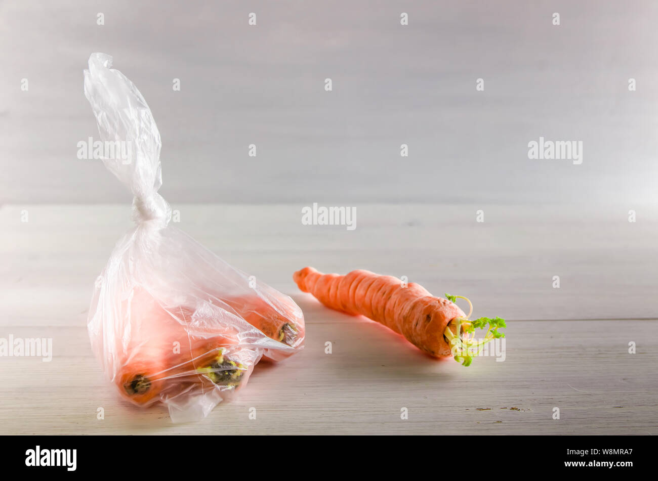 Plastique concept gratuitement les carottes dans un sac en plastique sur un fond blanc avec copie espace Banque D'Images