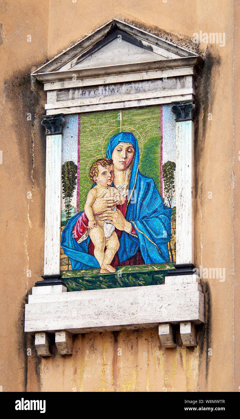 Une reproduction en mosaïque d'une peinture de Giovanni Bellini de la madone berçant l'enfant Christ, monté haut sur un mur de la rue de Crémone (Italie). Banque D'Images