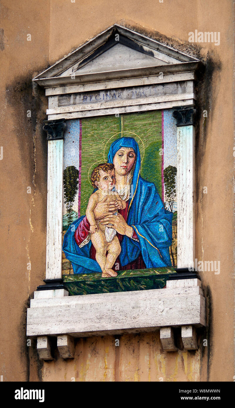 Une reproduction en mosaïque d'une peinture de Giovanni Bellini de la madone berçant l'enfant Christ, monté haut sur un mur de la rue de Crémone (Italie). Banque D'Images