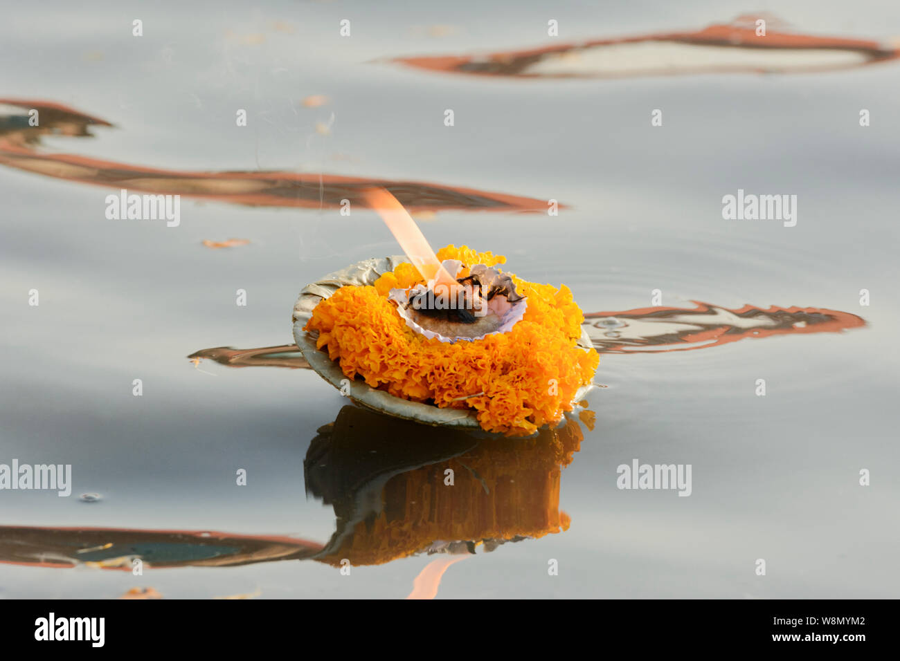 Une fleur de gravure bougie (une offrande aux dieux) flotte sur le Gange à Varanasi, Uttar Pradesh, Inde, Asie du Sud. Banque D'Images