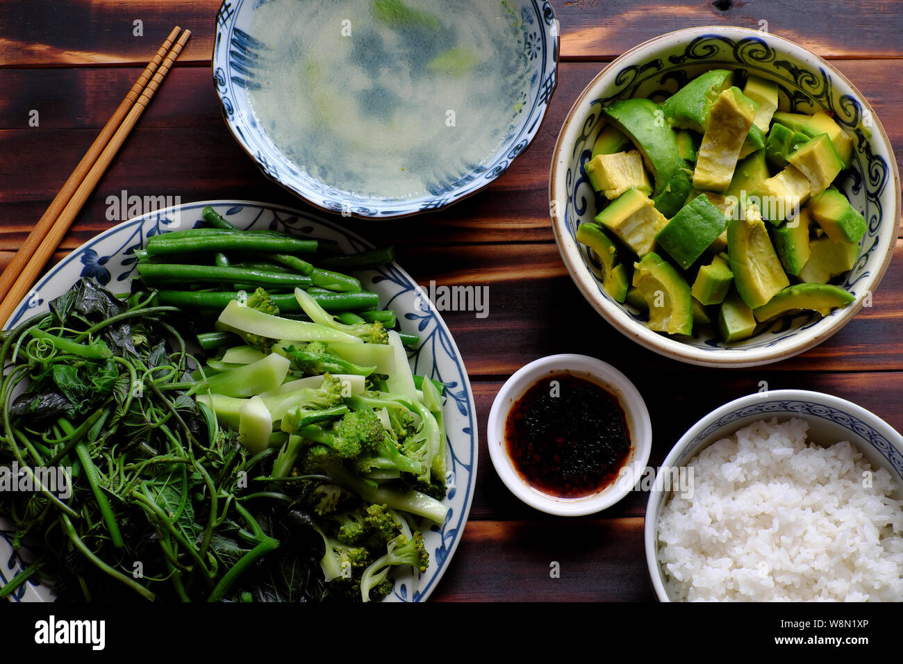 Vue de dessus repas végétarien vietnamien, des légumes bouillis avec string bean, le brocoli, les bourgeons de patate douce, salade d'avocat avec la sauce de soja et de riz, une alimentation non Banque D'Images