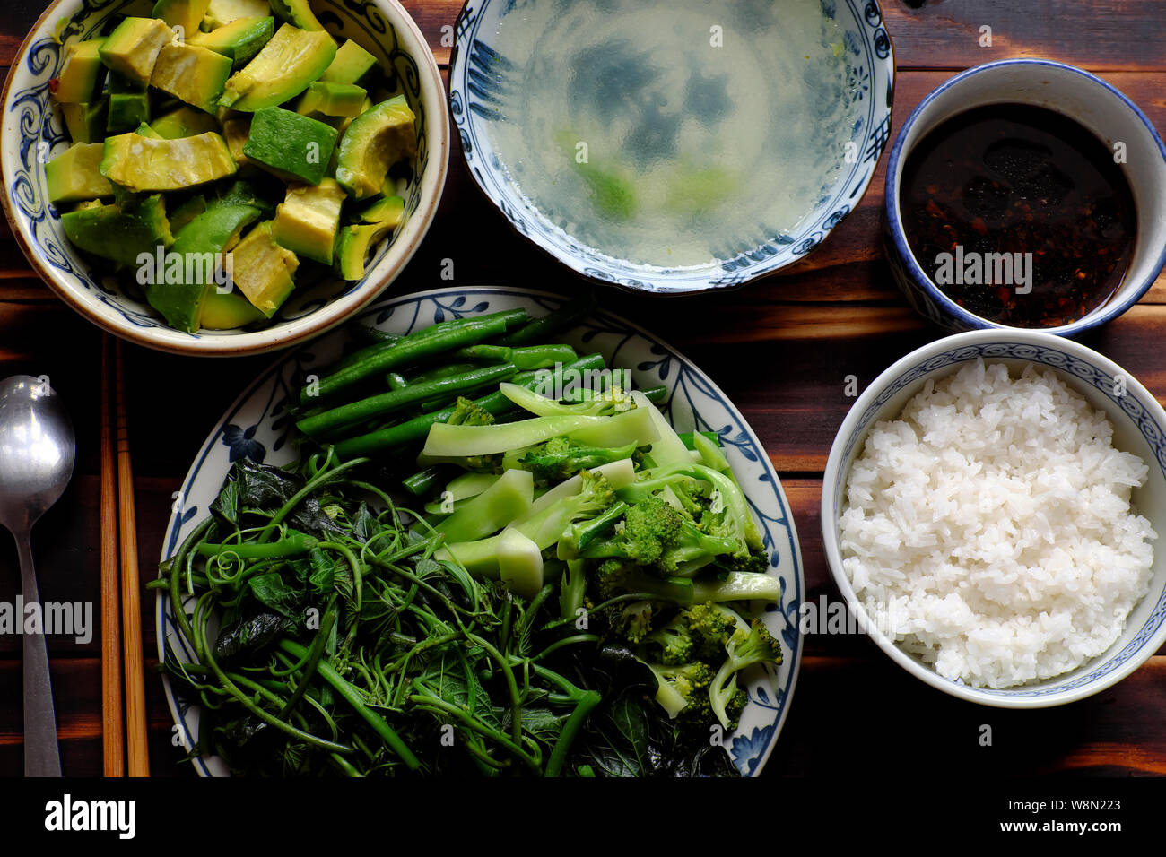 Vue de dessus repas végétarien vietnamien, des légumes bouillis avec string bean, le brocoli, les bourgeons de patate douce, salade d'avocat avec la sauce de soja et de riz, une alimentation non Banque D'Images