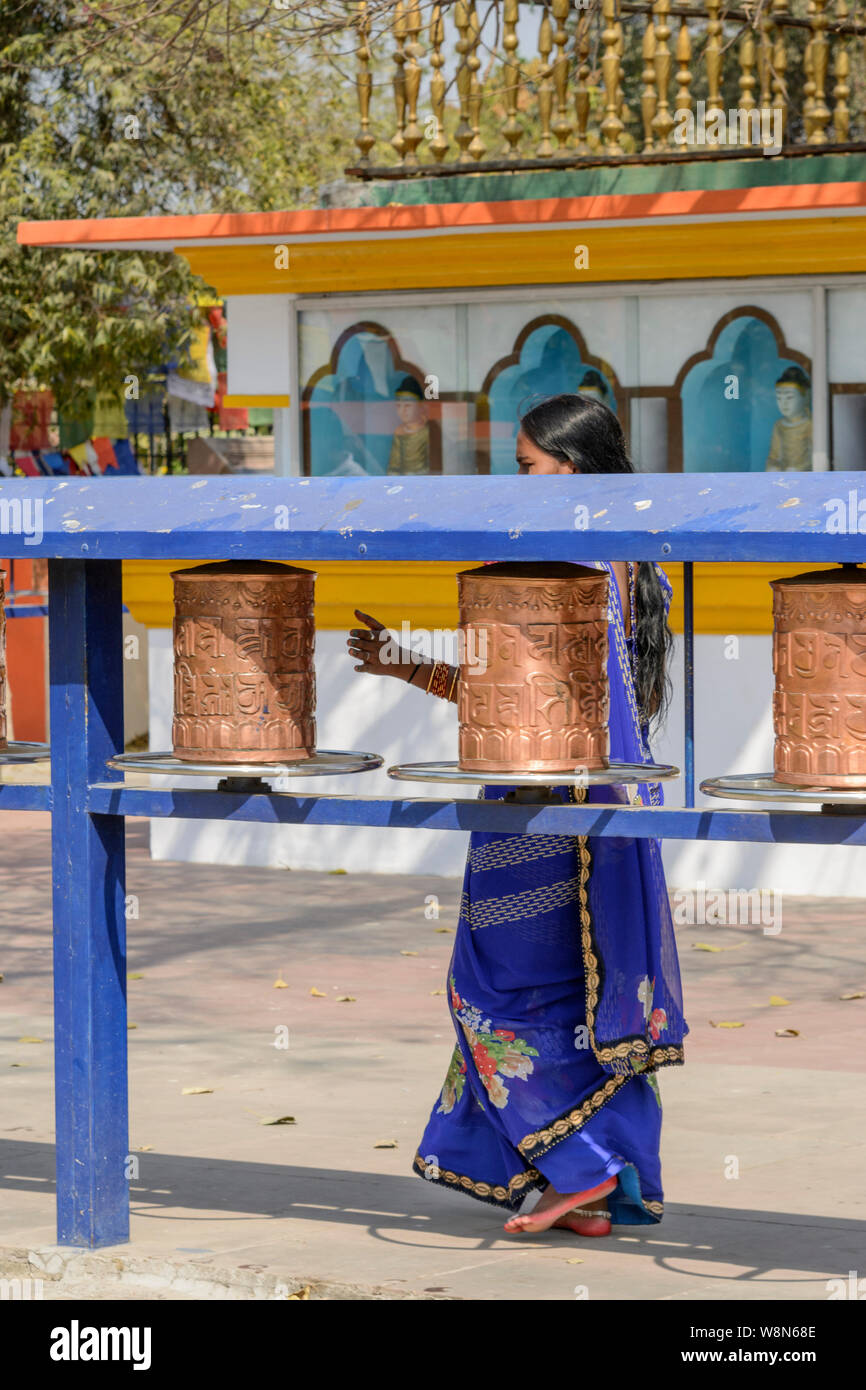 Une jeune femme indienne tourne la prière bouddhiste Mulagandha Kuti roues au Vihara à Sarnath, Uttar Pradesh, Inde, Asie, Asie du Sud Banque D'Images