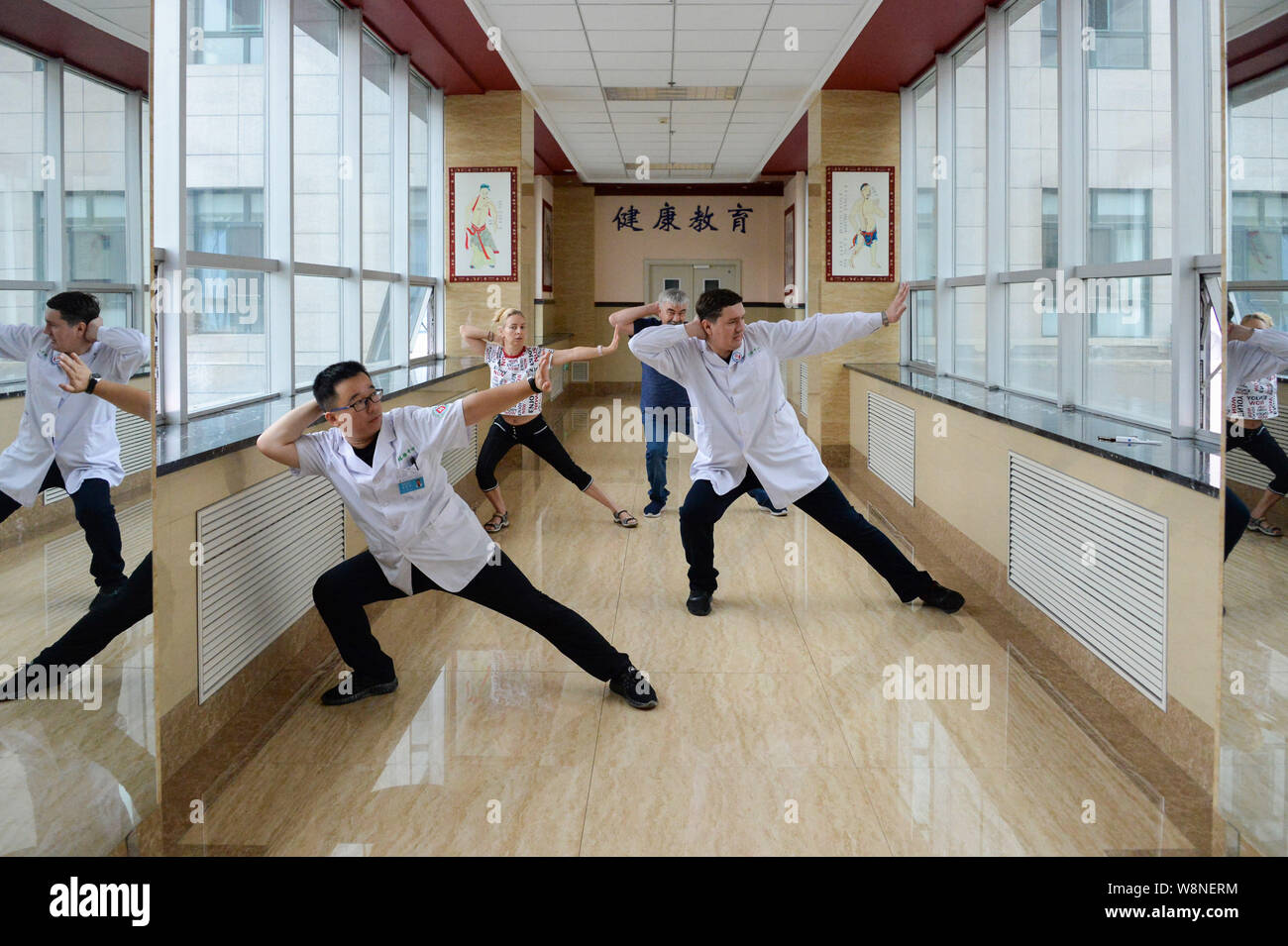 (190810) -- SHANGHAI, 10 août 2019 (Xinhua) -- Un Dong (1e R) et chef de l'examen physique Zha centre (1er Minghui L) Demandez aux patients russes de faire l'exercice de la médecine traditionnelle chinoise dans l'hôpital du peuple de Shanghai, la province du nord-est de la Chine, 10 août 2019. Un Dong, 40 ans, est un traducteur russe travaillant dans le centre d'examen physique de l'hôpital du peuple de Shanghai. Il est chargé de recevoir les patients russes, en les aidant à communiquer avec les médecins chinois, la traduction de leurs rapports d'examen médical chinois en version russe et en fournissant Banque D'Images