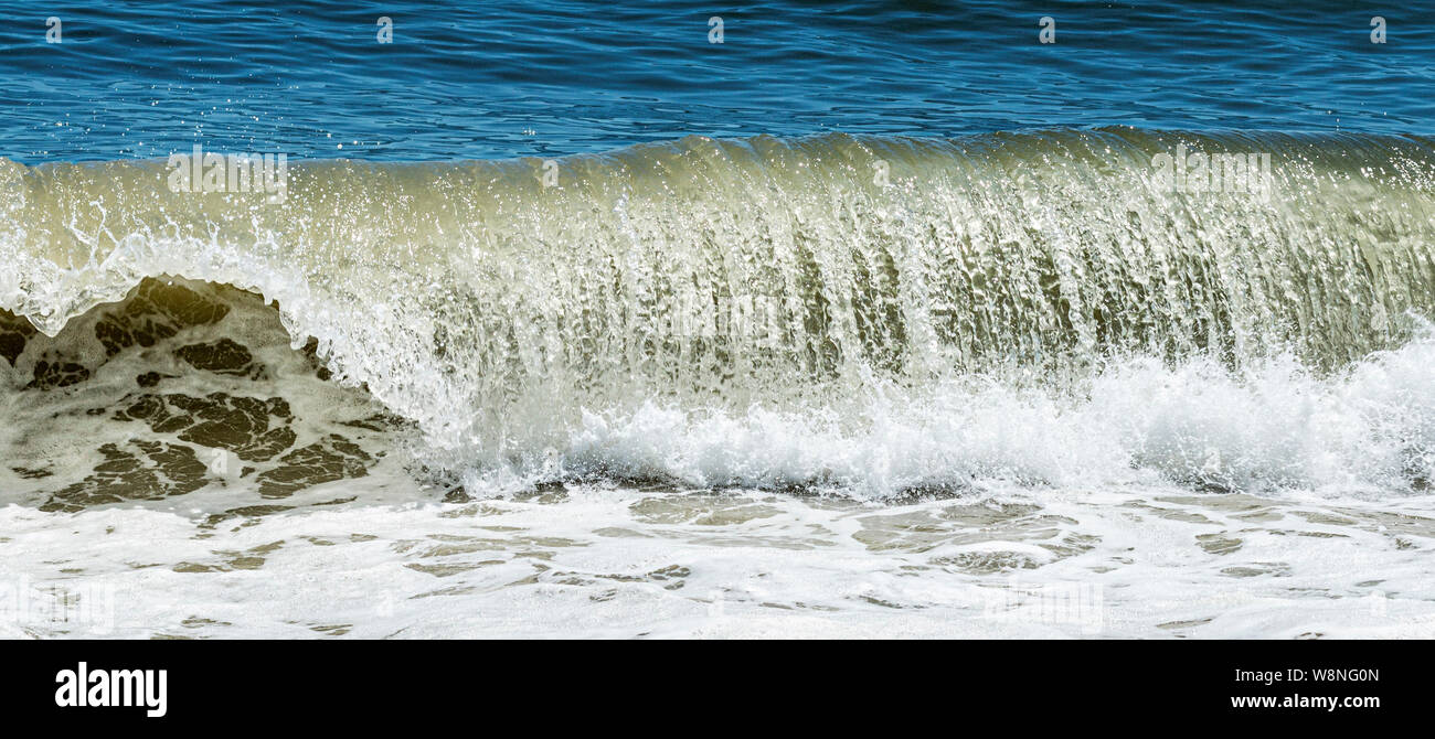 L'eau de l'océan bleu avec une belle vague de curling et de freinage des éclaboussures sur Fire Island National sea shore. Banque D'Images