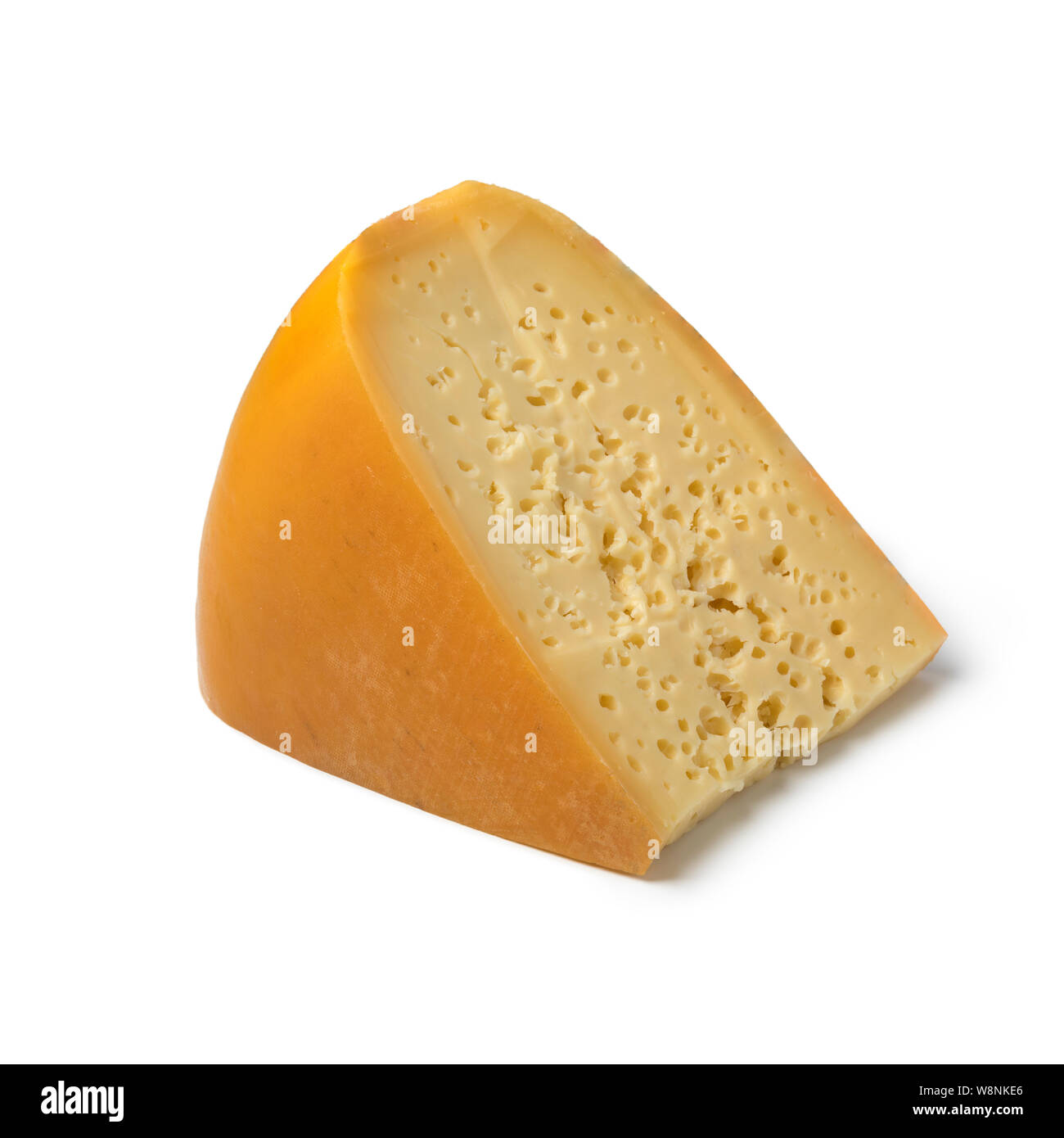 Morceau de fromage néerlandais Stolwijker avec trous isolé sur fond blanc Banque D'Images
