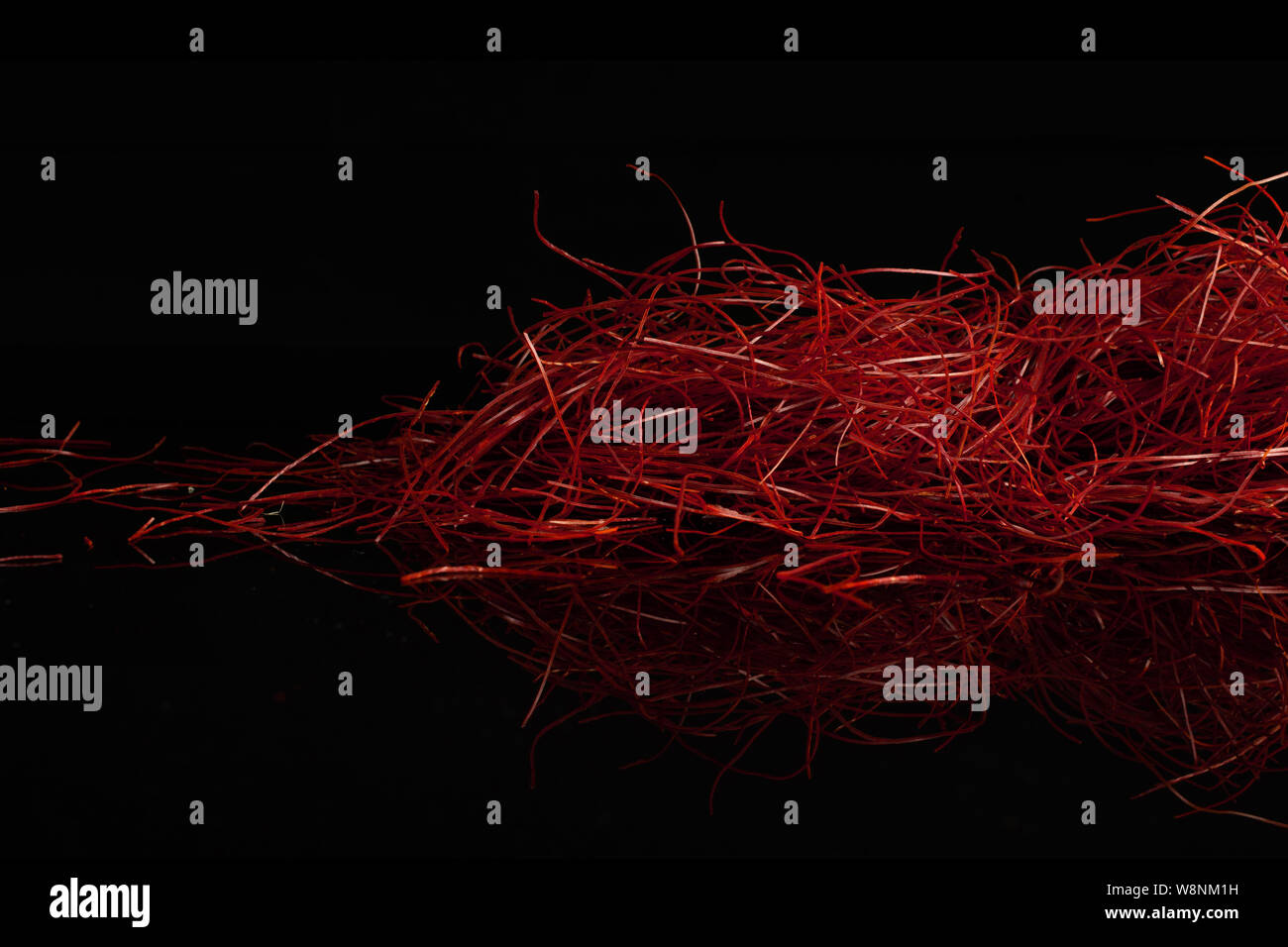 Lot de piment rouge vif threads isolé sur verre noir Banque D'Images