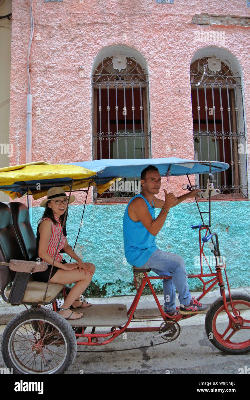Assez touristique d'Asie pose pour photo avec conducteur de pousse-pousse dans la vieille Havane Banque D'Images