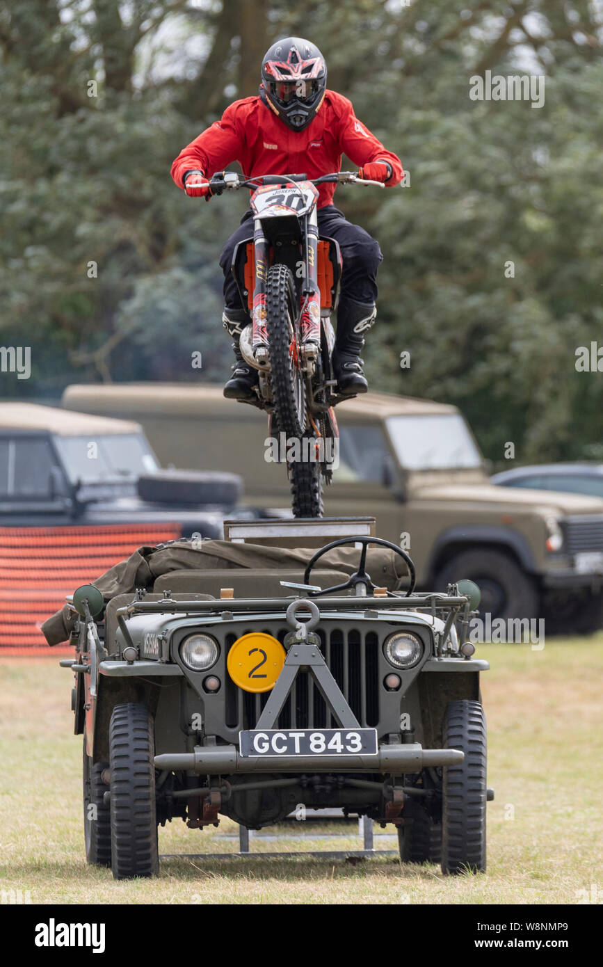 Organisé par l'Association des véhicules militaires historiques Essex, les échos de l'événement historique est un week-end complet de l'affiche et de divertissement. militaire Rider de l'équipe moto tigres sautant au dessus d'une Jeep Banque D'Images