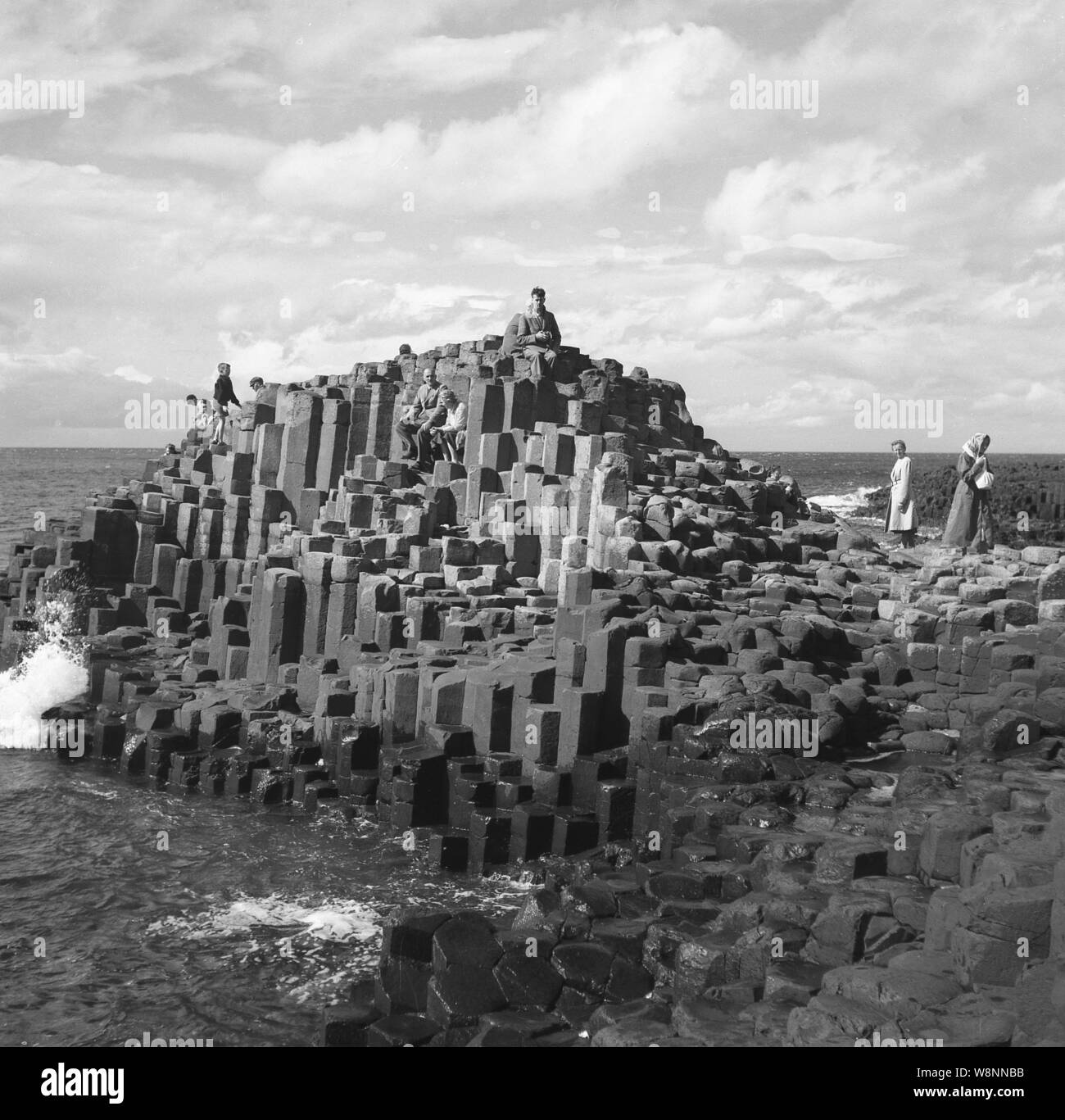 Années 1950, historiques, les gens sur les colonnes de basalte hexagonal à la Giant's Causeway, Antirm Co., l'Irlande du Nord, Royaume-Uni. Au nord de l'océan Atlantique, sur la côte de causeway, ils sont le résultat d'une ancienne fissure volcanique éruption. Banque D'Images