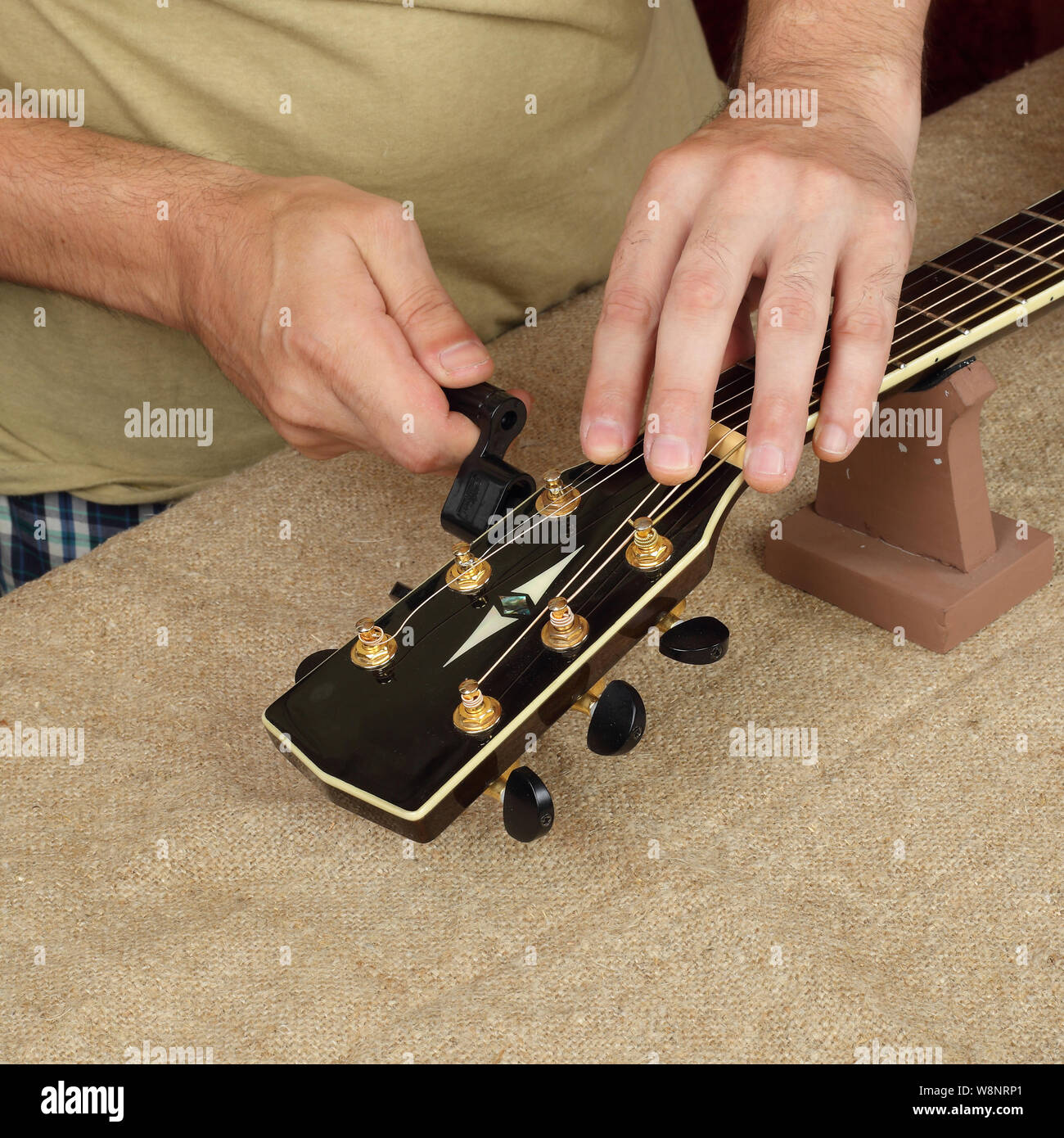 Réparation guitare instrument de musique et le service des travailleurs - fixer de nouvelles cordes guitare acoustique noir Banque D'Images