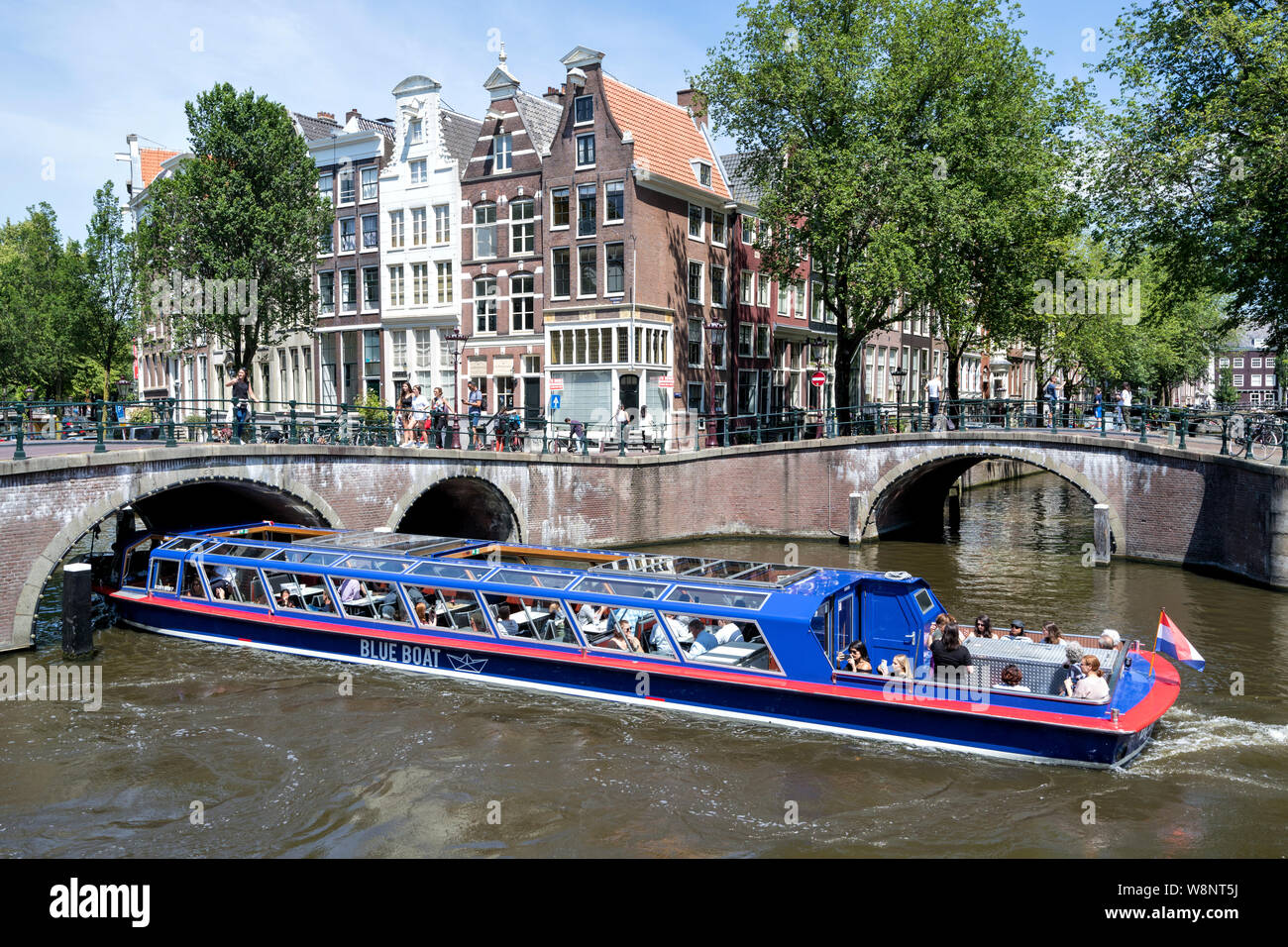 Du canal d'Amsterdam, VILLE D'AMSTERDAM en bateau de bateau bleu au Keizersgracht/ Leidsegracht intersection. Banque D'Images