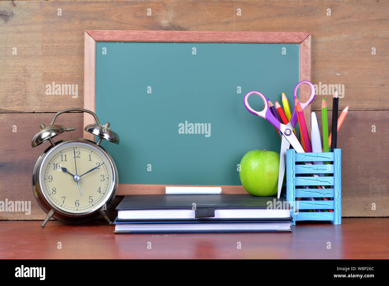 Concept Retour à l'école avec des livres et un réveil avec chalkboard Banque D'Images