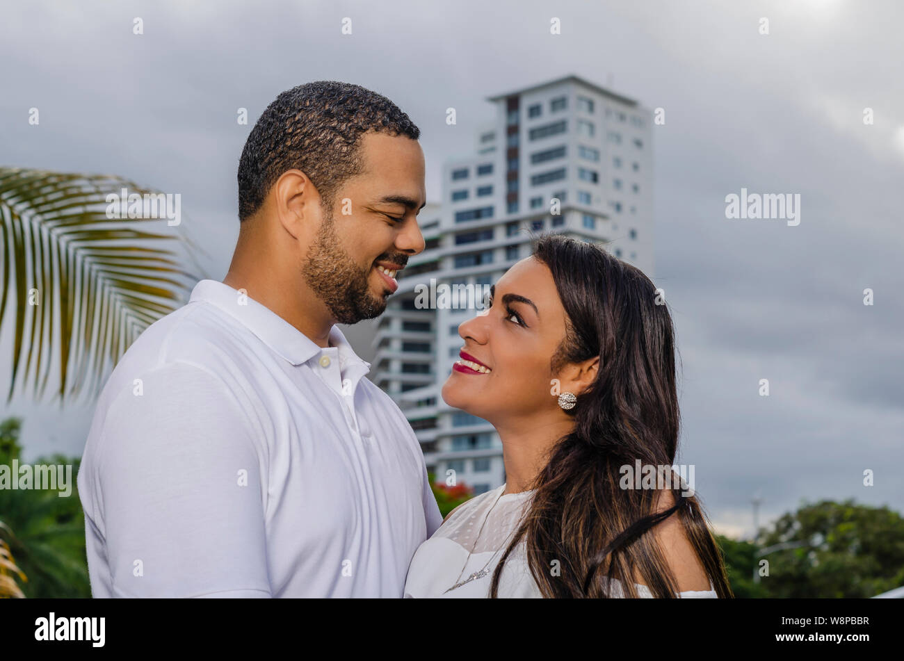Couple de jeunes hommes et femmes d'Amérique latine et heureux à l'extérieur en portrait, ensemble dans un parc, ju à la fois rire et romantique hugging Banque D'Images