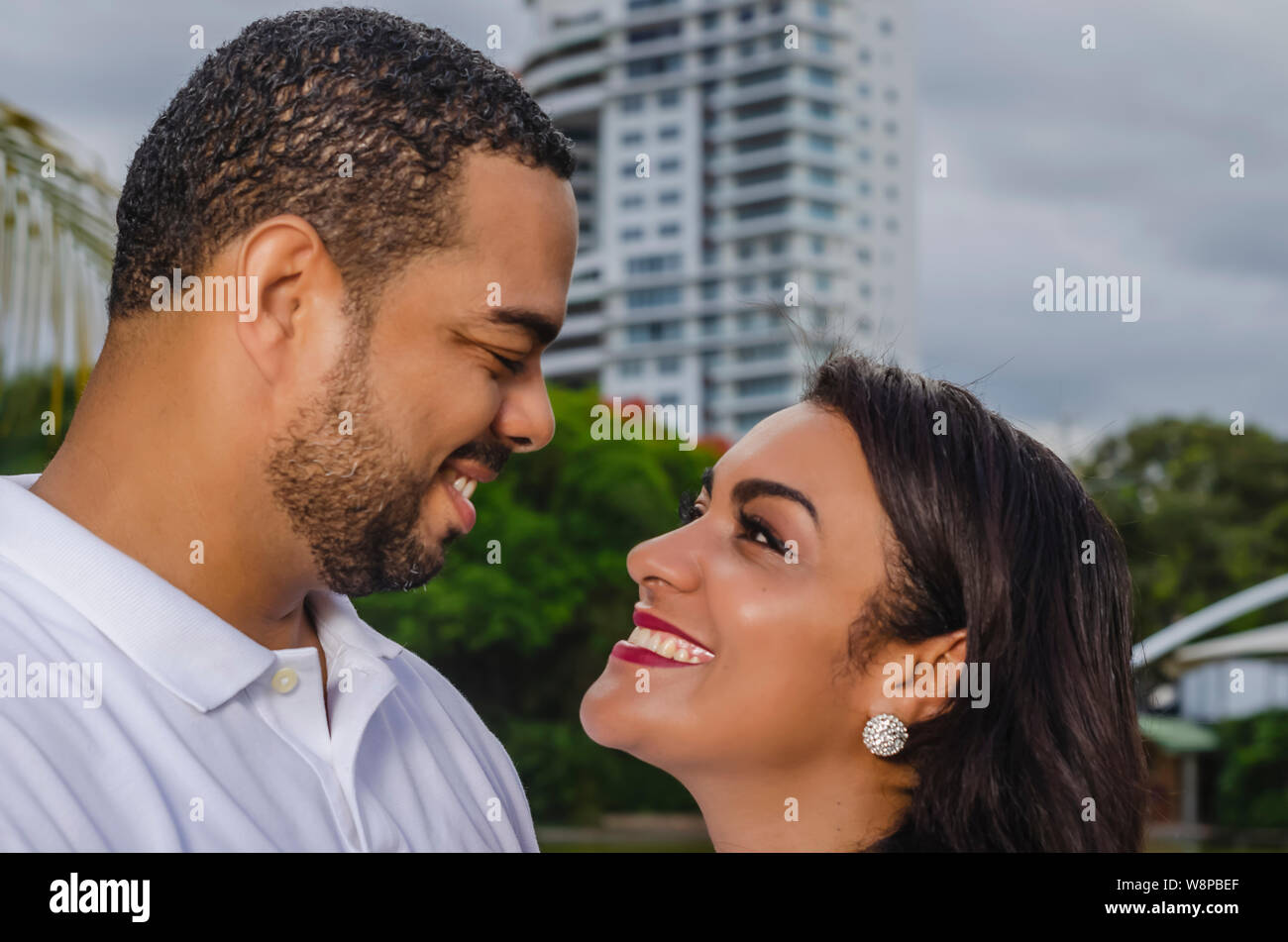 Couple de jeunes hommes et femmes d'Amérique latine et heureux à l'extérieur en portrait, ensemble dans un parc, ju à la fois rire et romantique hugging Banque D'Images