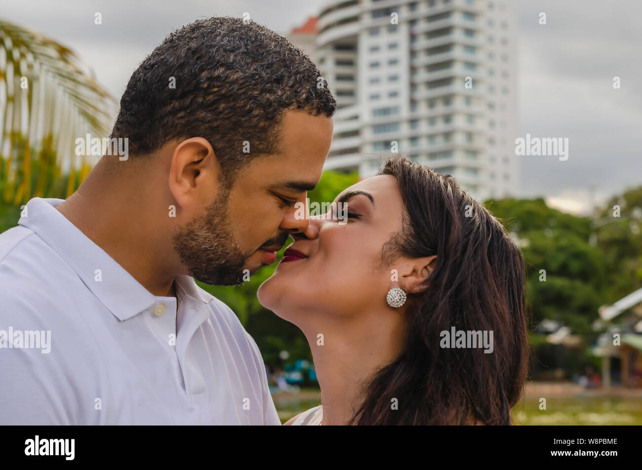 Couple de jeunes hommes et femmes d'Amérique latine et heureux à l'extérieur en portrait, ensemble dans un parc, ju à la fois rire et romantique hugging Banque D'Images