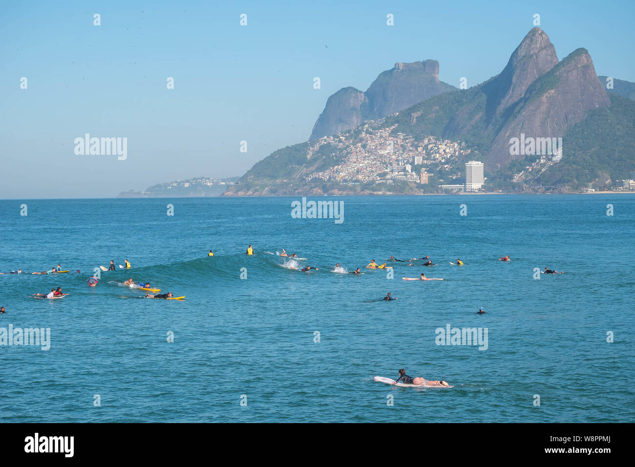 Rio de Janeiro, Brésil - le 10 août 2019 : la plage d'Ipanema et d'Arpoador avec surfeurs amateurs en attente de vagues sur les eaux bleues et les montagnes en zone Banque D'Images