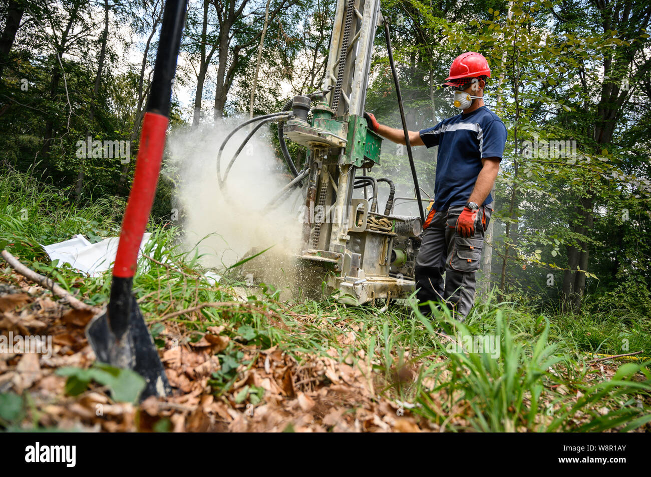 Wittmar, Allemagne. Le 08 août, 2019. Un homme exploite une perceuse que des exercices à 15 mètres de profondeur de trou place une charge explosive qui est utilisé pour mesurer la structure du sol autour de l'Asse 2 référentiel nucléaire. Autour de 6500 les charges d'explosifs doivent être distribués dans la forêt. 45 000 capteurs sismographiques seront ensuite diffusées sur le site pour enregistrer les vibrations de l'explosion. Credit : Christophe Gateau/dpa/Alamy Live News Banque D'Images