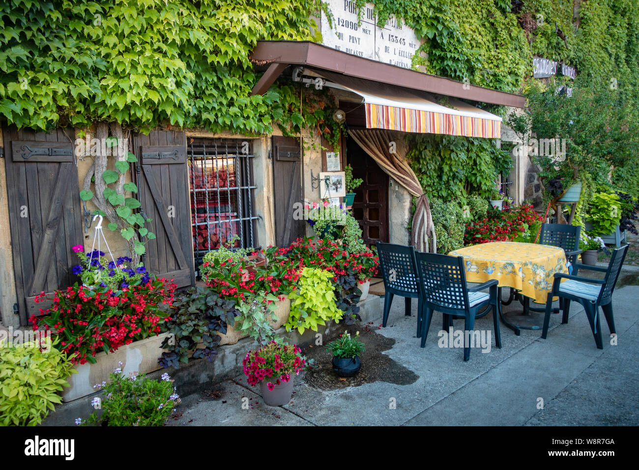 Coin repas et tables sur une terrasse de restaurant français à Somail, France. Banque D'Images