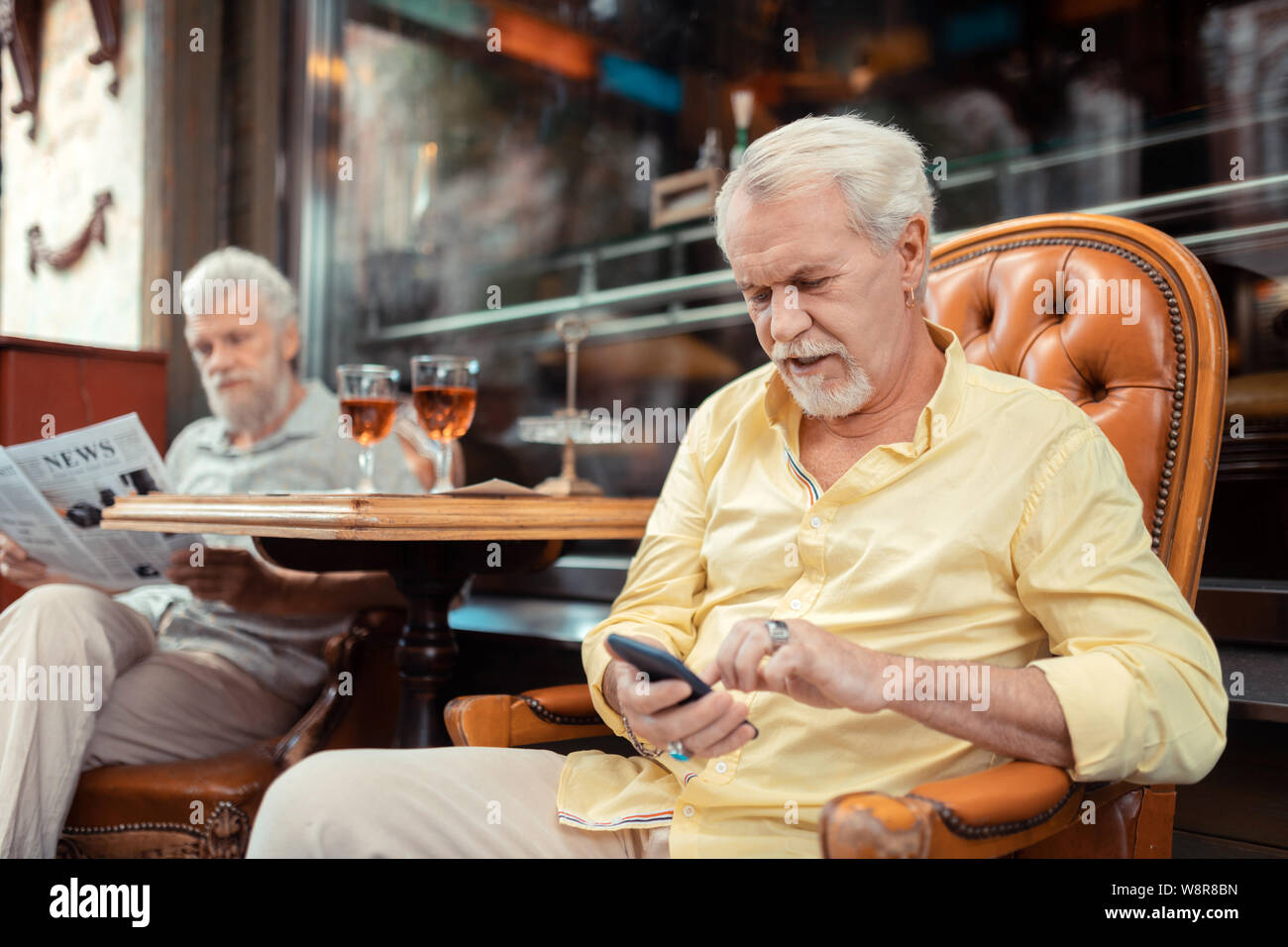 Aged man wearing bagues massives texting sa femme Banque D'Images