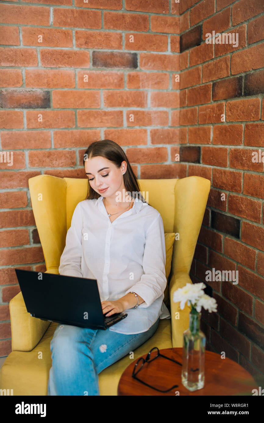 Jeune femme réussi à travailler sur un ordinateur portable dans un café noir Banque D'Images
