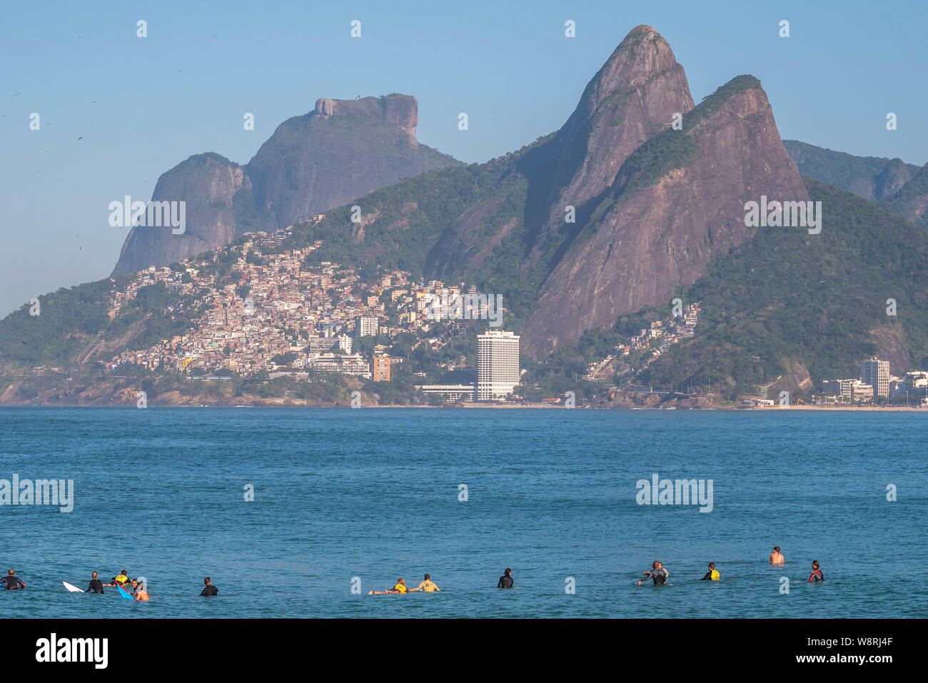 Rio de Janeiro, Brésil - le 10 août 2019 : la plage d'Ipanema et d'Arpoador avec surfeurs amateurs en attente de vagues sur les eaux bleues et les montagnes en zone Banque D'Images