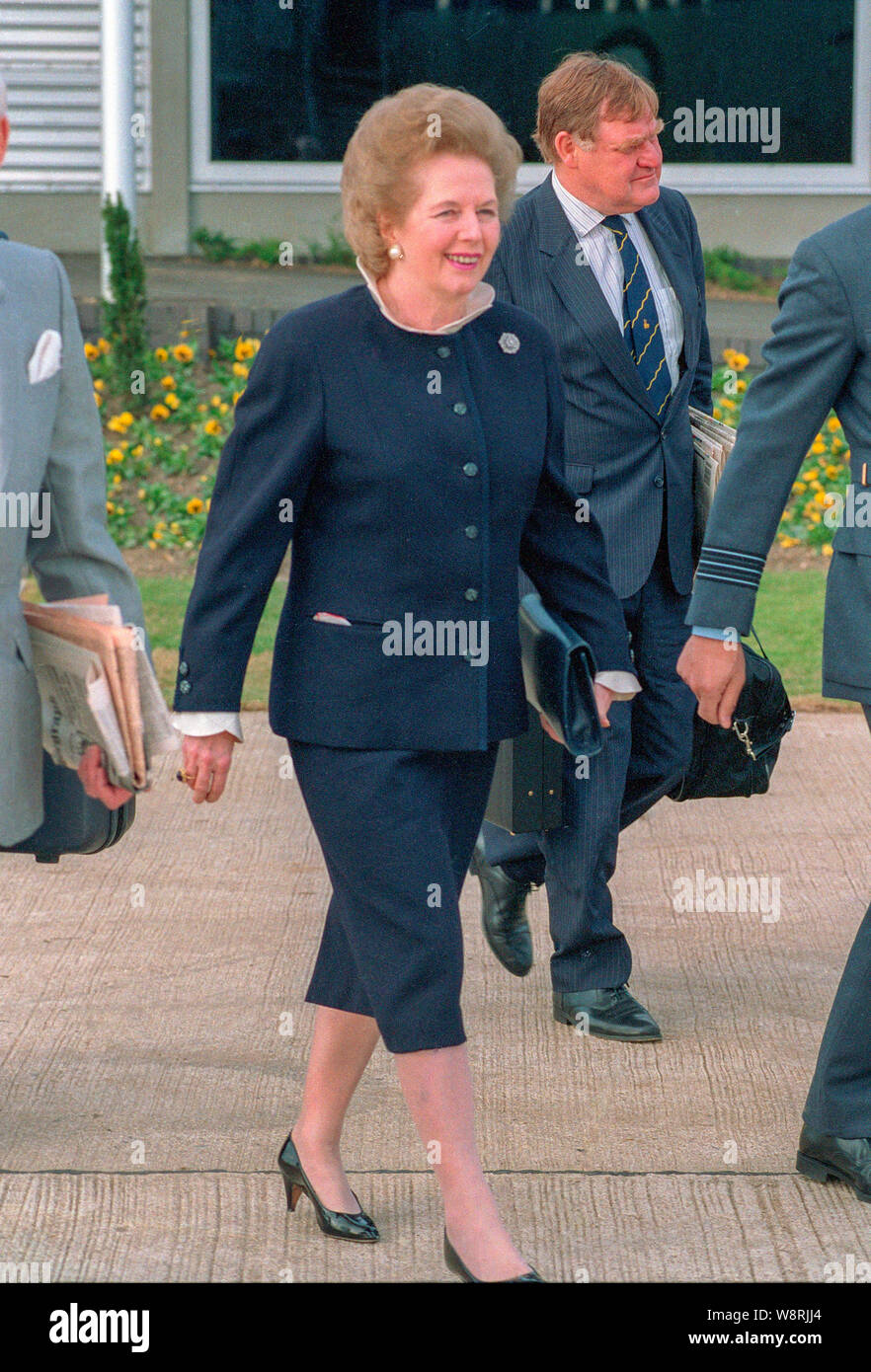Le Premier ministre britannique Margaret Thatcher Quitter Heathrow avec mari Dennis et secrétaire de presse Bernard Ingham. Banque D'Images