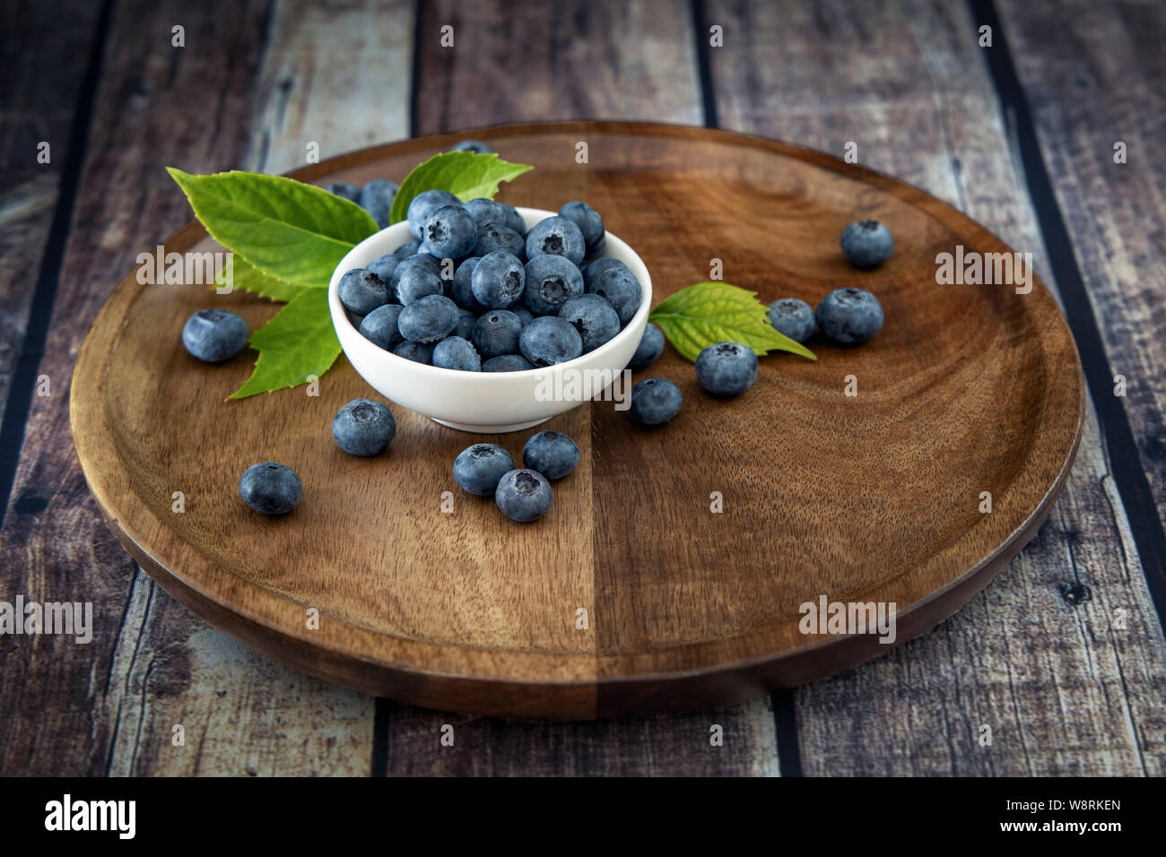 Cassis Cassis frais mûrs de petits fruits sur une vieille table en bois vintage avec des feuilles vertes. Cassis fruits naturels juteux. Banque D'Images