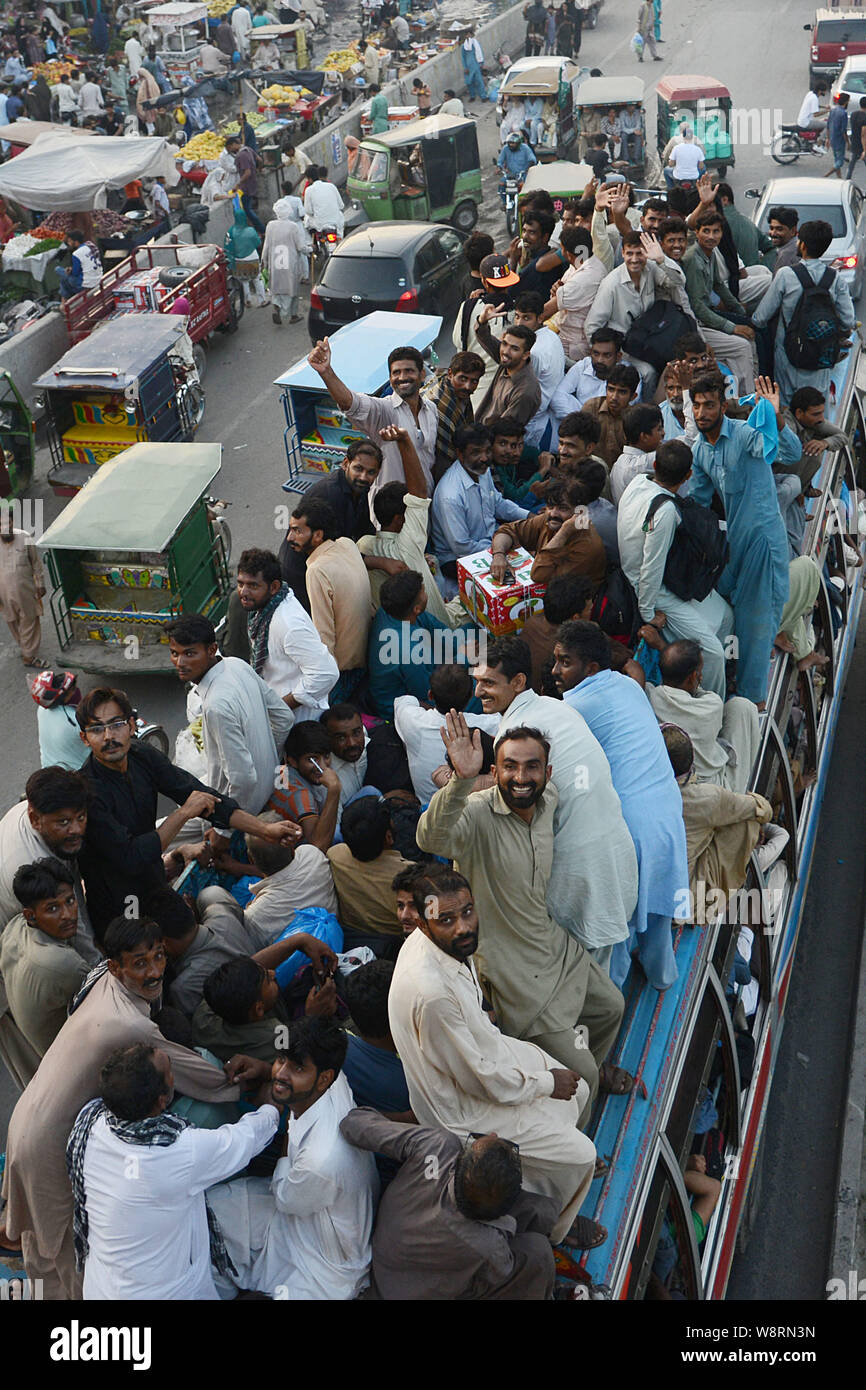 Les Pakistanais passagers monter sur le toit de bus juste pour prendre un tour à retourner à leur ville natale et villages pour célébrer l'Aïd al-Adha avec leur amour l'un et les membres de la famille. Les musulmans du monde entier commencent à se préparer à "l'Aïd al-Adha", un festival de sacrifier Bovins, chèvres et moutons en commémoration du Prophète Abraham est prêt à sacrifier son fils et pour montrer son obéissance à Dieu. Le festival marque la fin du Hajj où des millions de musulmans effectuer le pèlerinage annuel à La Mecque. (Photo par Rana Sajid Hussain/Pacific Press) Banque D'Images