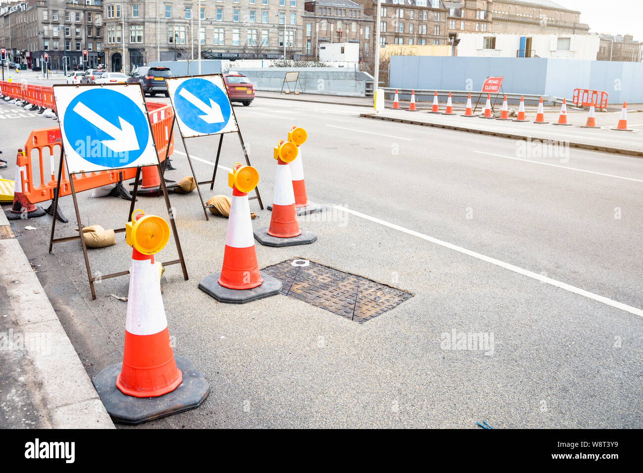 Signes et cônes de signalisation indiquant la fermeture d'un laneof une large rue car des travaux routiers dans le centre d'une ville Banque D'Images