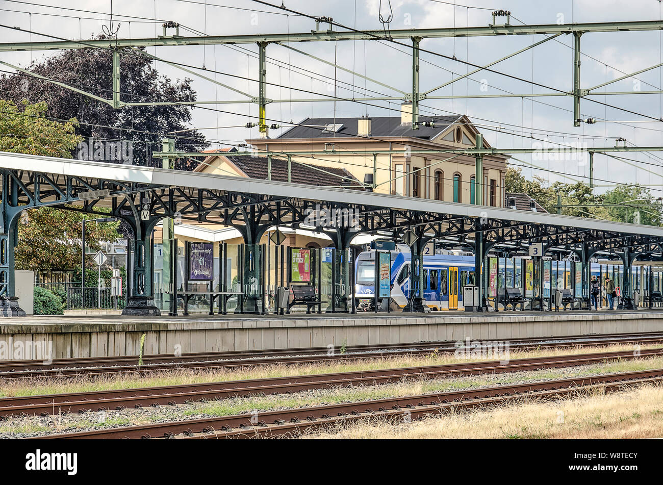 Meppel, aux Pays-Bas, le 26 juillet 2019 : des voies de chemin de fer , les câbles aériens et d'une plate-forme à la gare avec le bâtiment de la gare monumentale dans Banque D'Images