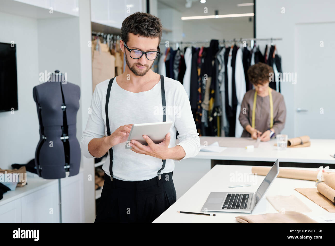 Jeune homme sérieux avec sur mesure à la tablette grâce à des idées créatives en ligne Banque D'Images