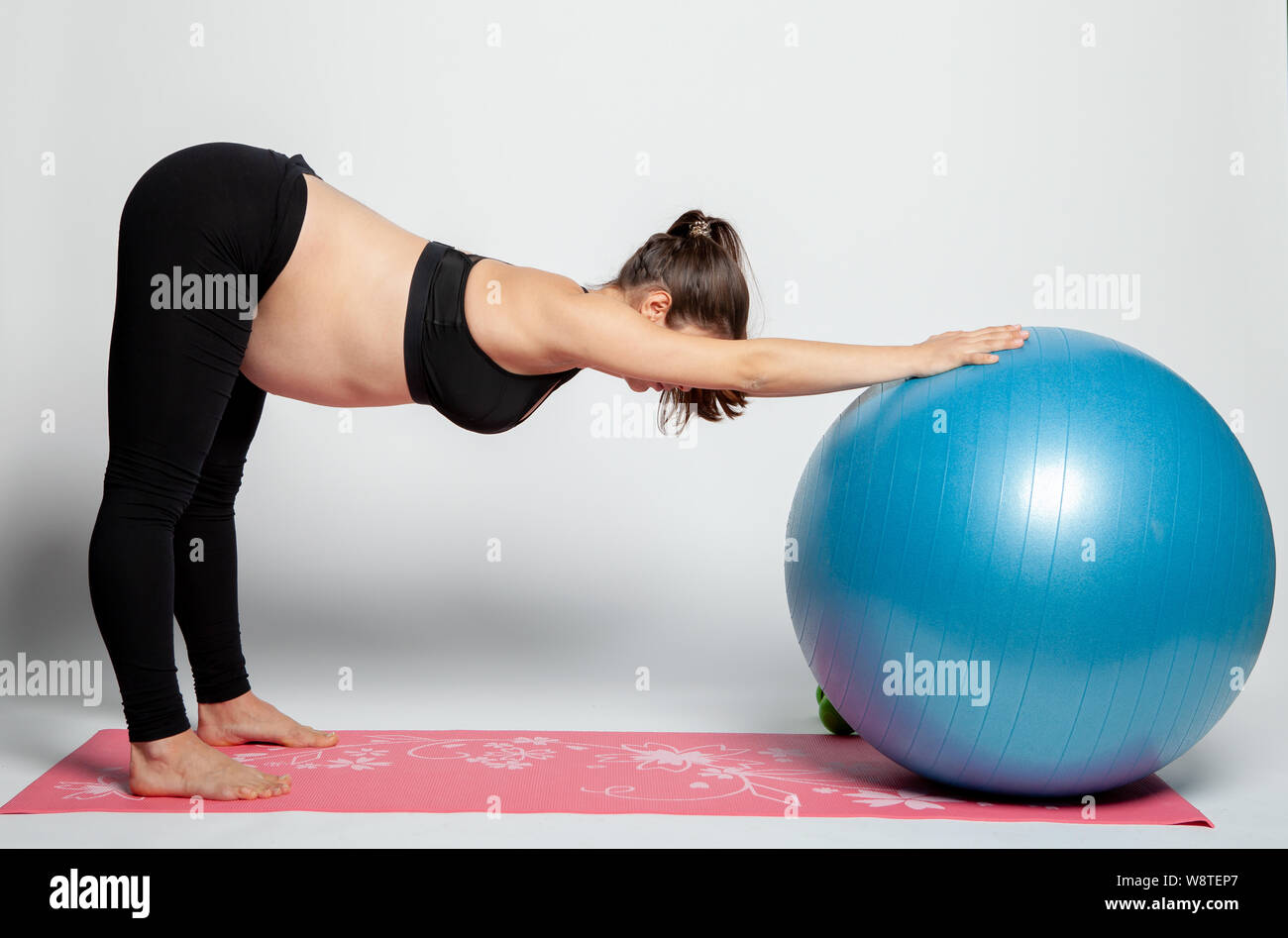 Young pregnant woman doing gymnastics avec fitball et haltères. Banque D'Images