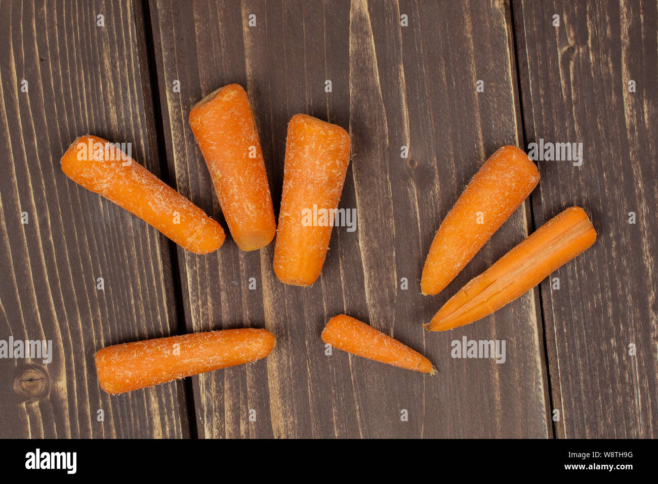 Beaucoup D Orange Bebe Rassis Rassis Bebe Carotte Flatlay Isole Sur Bois Marron Fonce Photo Stock Alamy