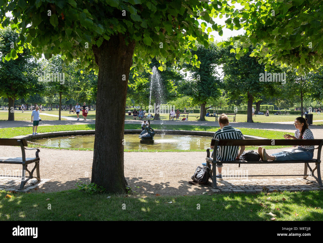 Parc de Copenhague ; les gens se détendre sous le soleil d'été en août à Kongens Have ( Les rois garden ), le centre-ville de Copenhague, Danemark Copenhague Banque D'Images