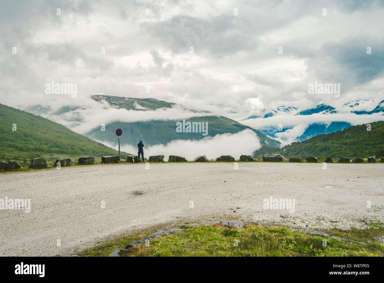L'homme à prendre des photos photographe casque vue arrière de la montagne paysage en temps de pluie en Norvège. Style de voyage. Adventure concept Wanderlust Banque D'Images