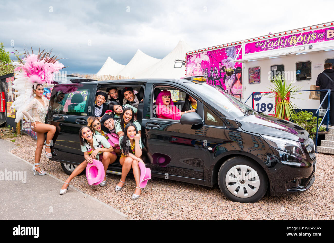 Lady Boys of Bangkok, Edinburgh Festival Fringe, Écosse, Royaume-Uni comme drag artistes Cram dans le taxi dans des costumes colorés Banque D'Images