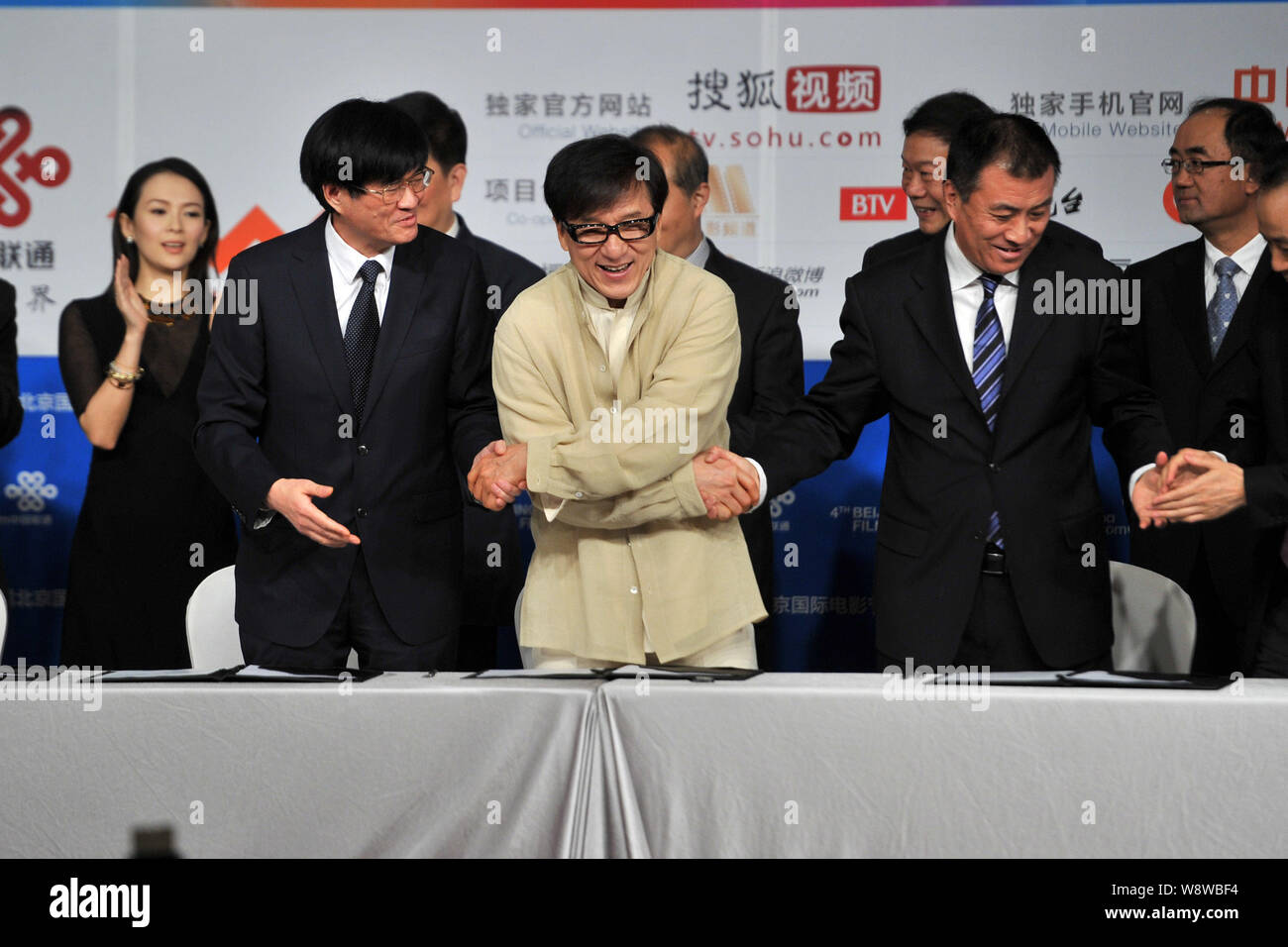 L'acteur de Hong Kong Jackie Chan, l'avant centre, serre la main avec les représentants de groupes d'investissement de film au cours d'une cérémonie de prise de vue pour son nouveau film dans Banque D'Images