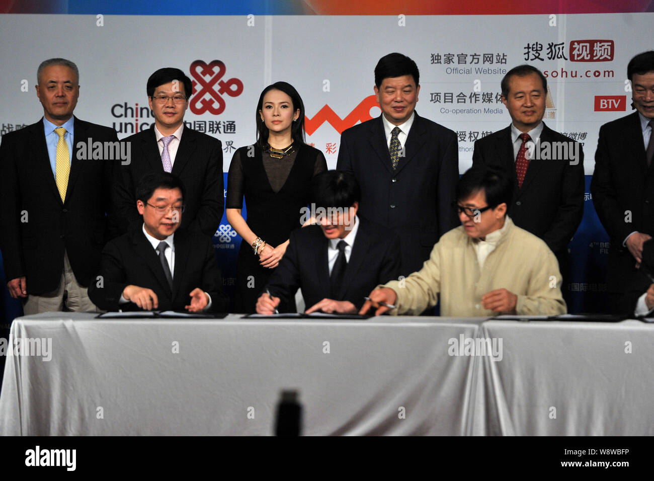 L'acteur de Hong Kong Jackie Chan, avant droit, signe un accord avec les représentants de groupes d'investissement de film au cours d'une cérémonie de prise de vue pour son nouveau mov Banque D'Images