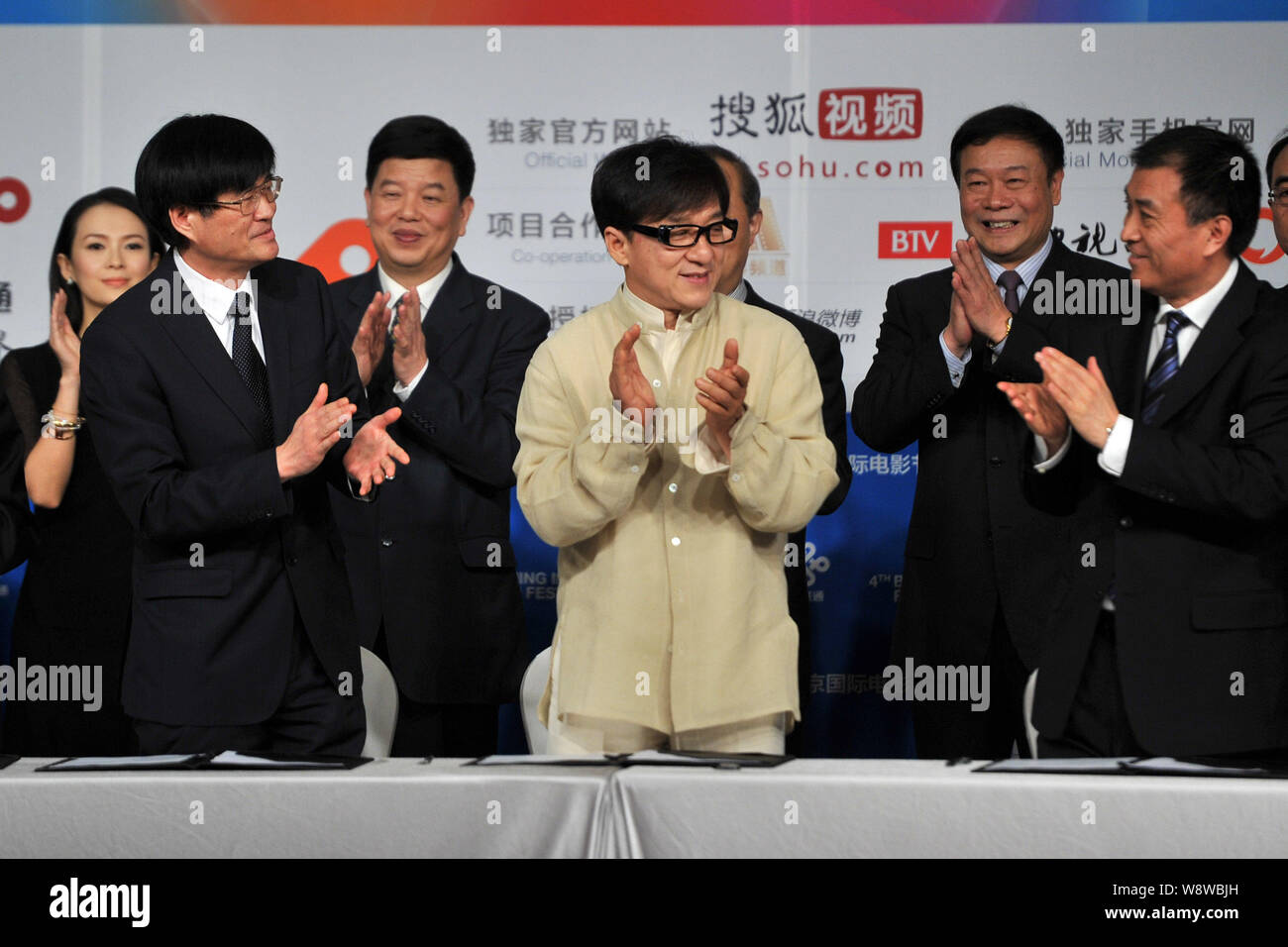 L'acteur de Hong Kong Jackie Chan, l'avant centre, applaudit après avoir signé un accord avec les représentants de groupes d'investissement de film au cours d'une cérémonie de prise de vue Banque D'Images